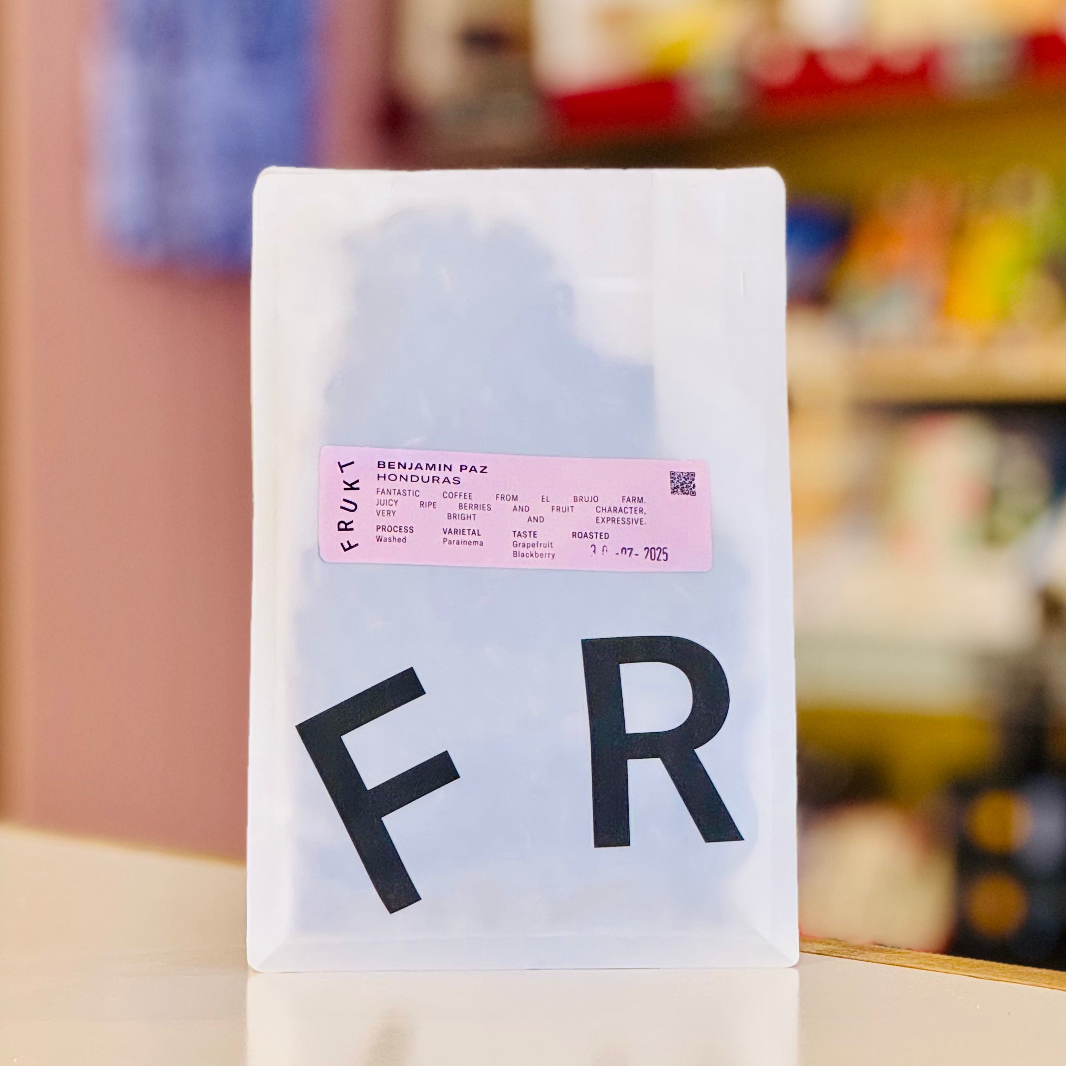 White coffee bag with 'FR' on a blurred background