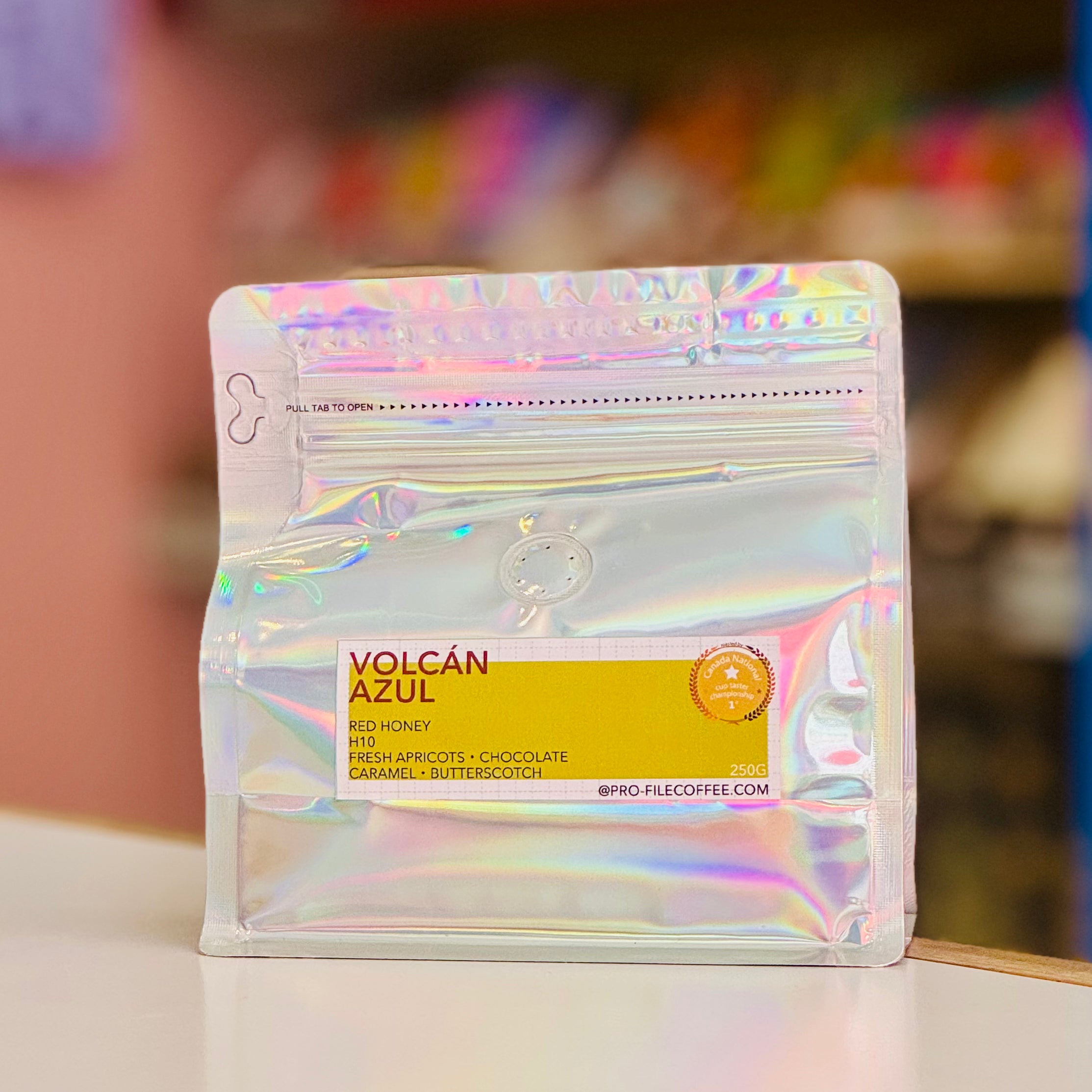 Holographic coffee bag with 'Volcan Azul' label on a blurred background