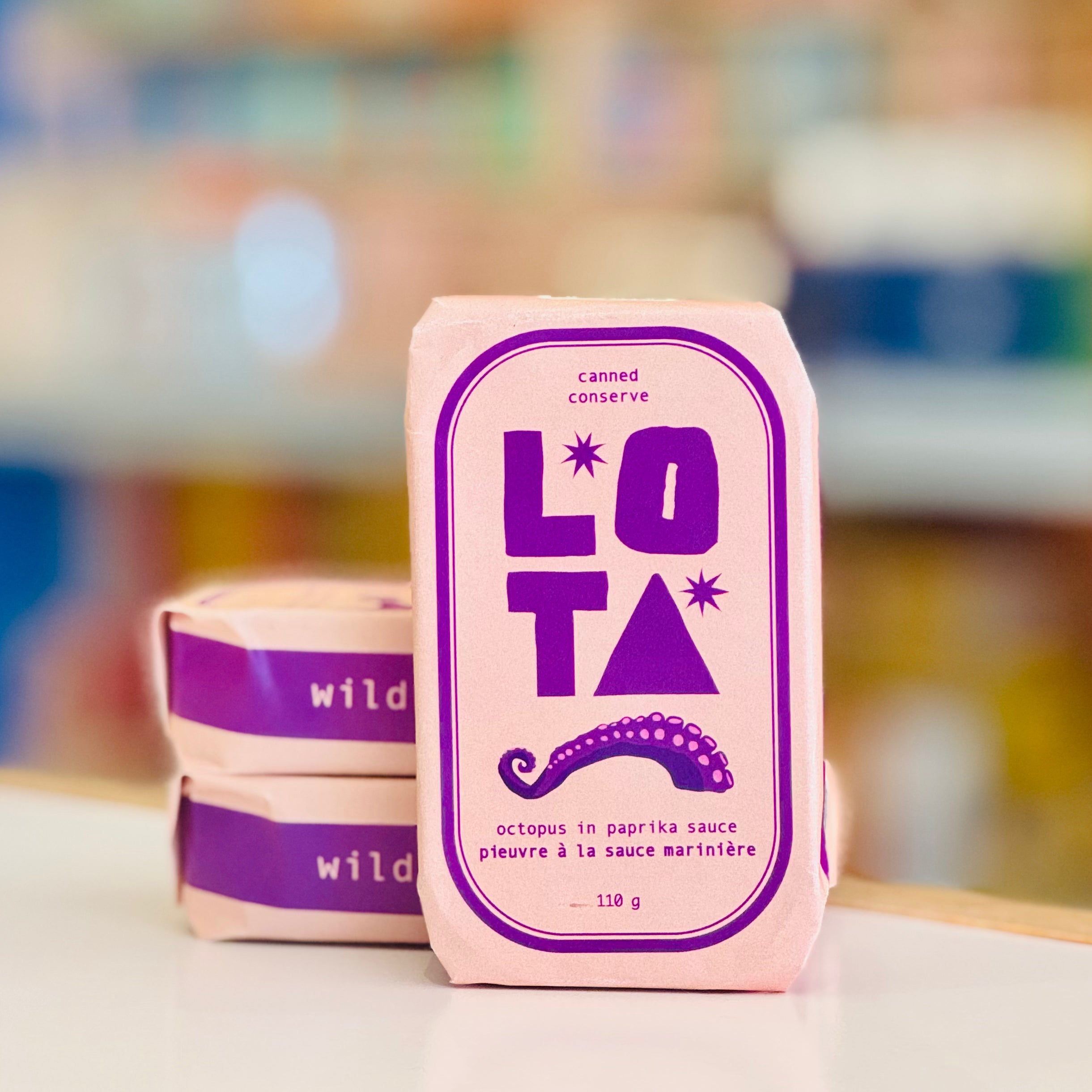 Canned food packaging with 'LOTA' branding on a blurred background