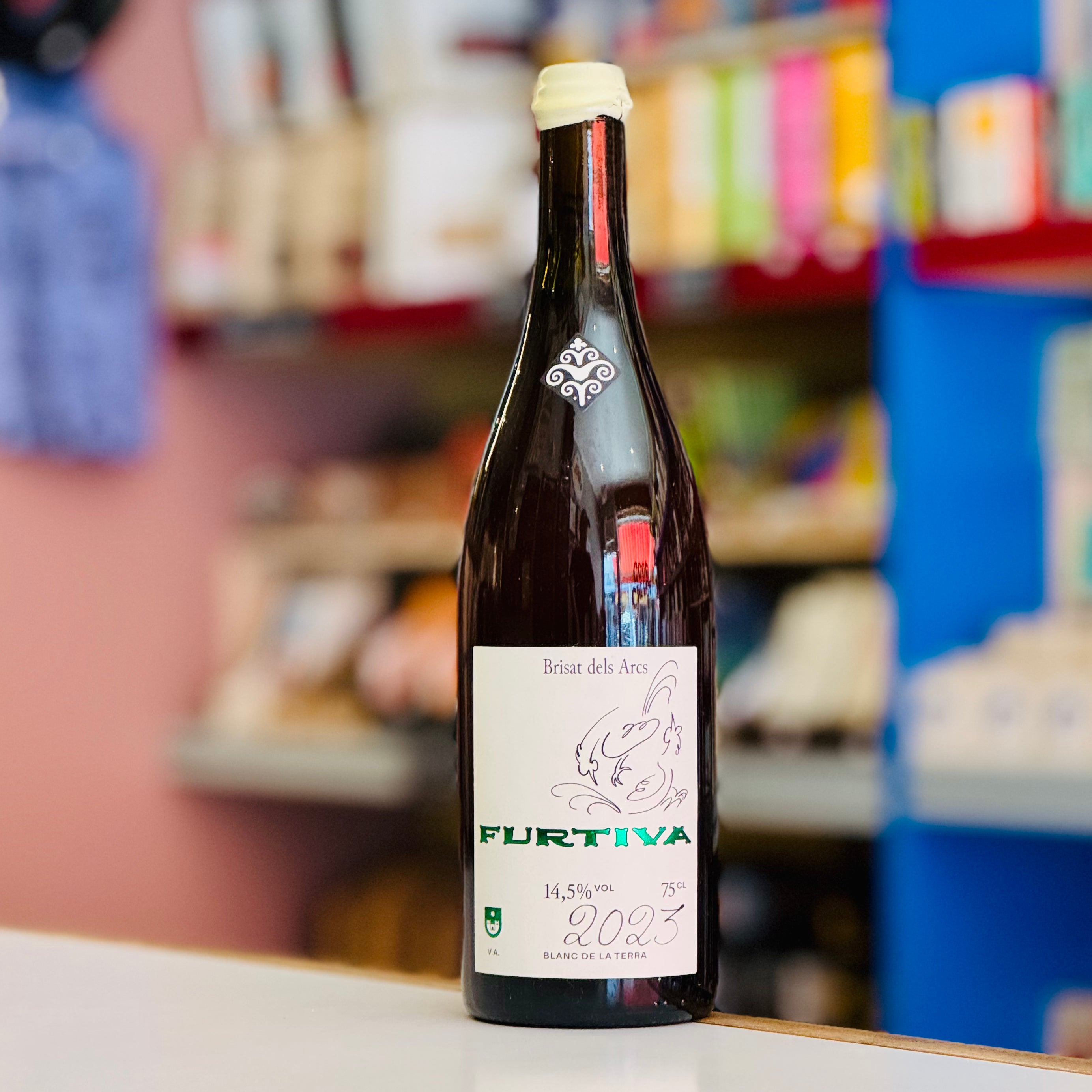 Wine bottle labeled 'Furtiva' on a counter with a blurred store background