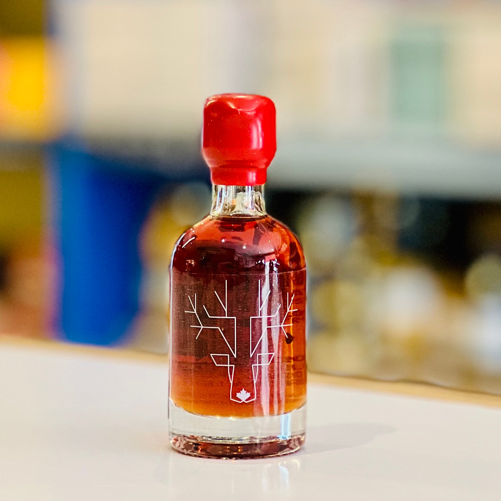 Small bottle with red cap and intricate design on a blurred background