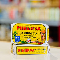 Two Minerva Sardinhas fish paste tubes stacked on a light surface with a blurred supermarket background.