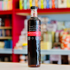 Bottle of maple syrup with a label in a store setting