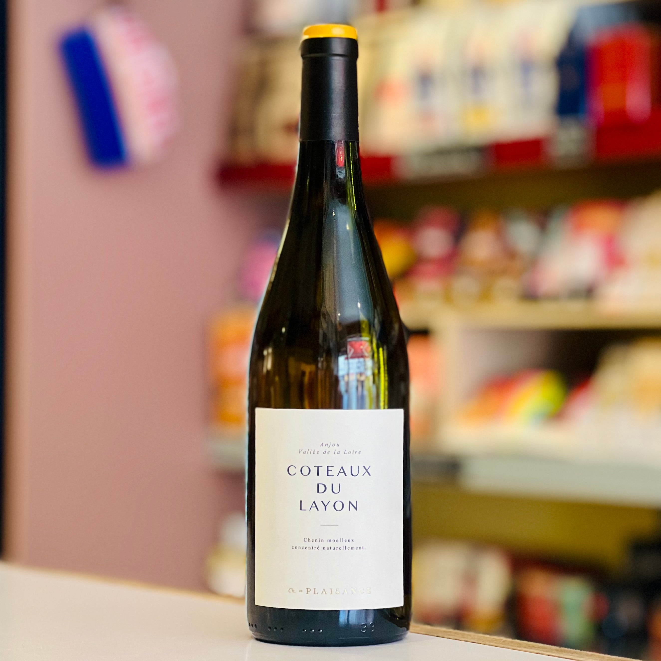 Bottle of Coteaux du Layon wine on a shelf with blurred store background