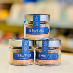 Three jars of 'Le Mareviglie' bottarga on a blurred background