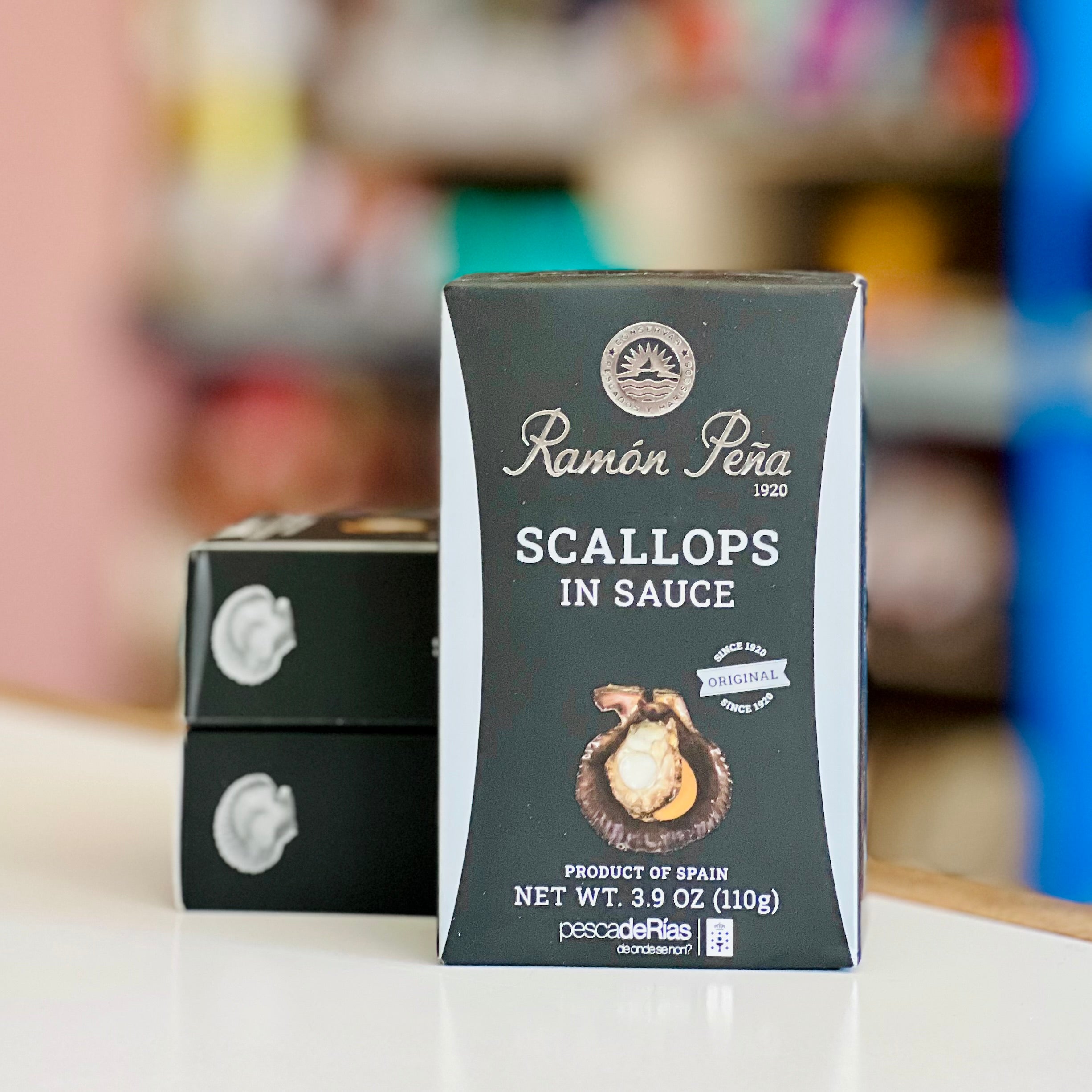 Packaging of Ramón Péra scallops in sauce on a blurred background