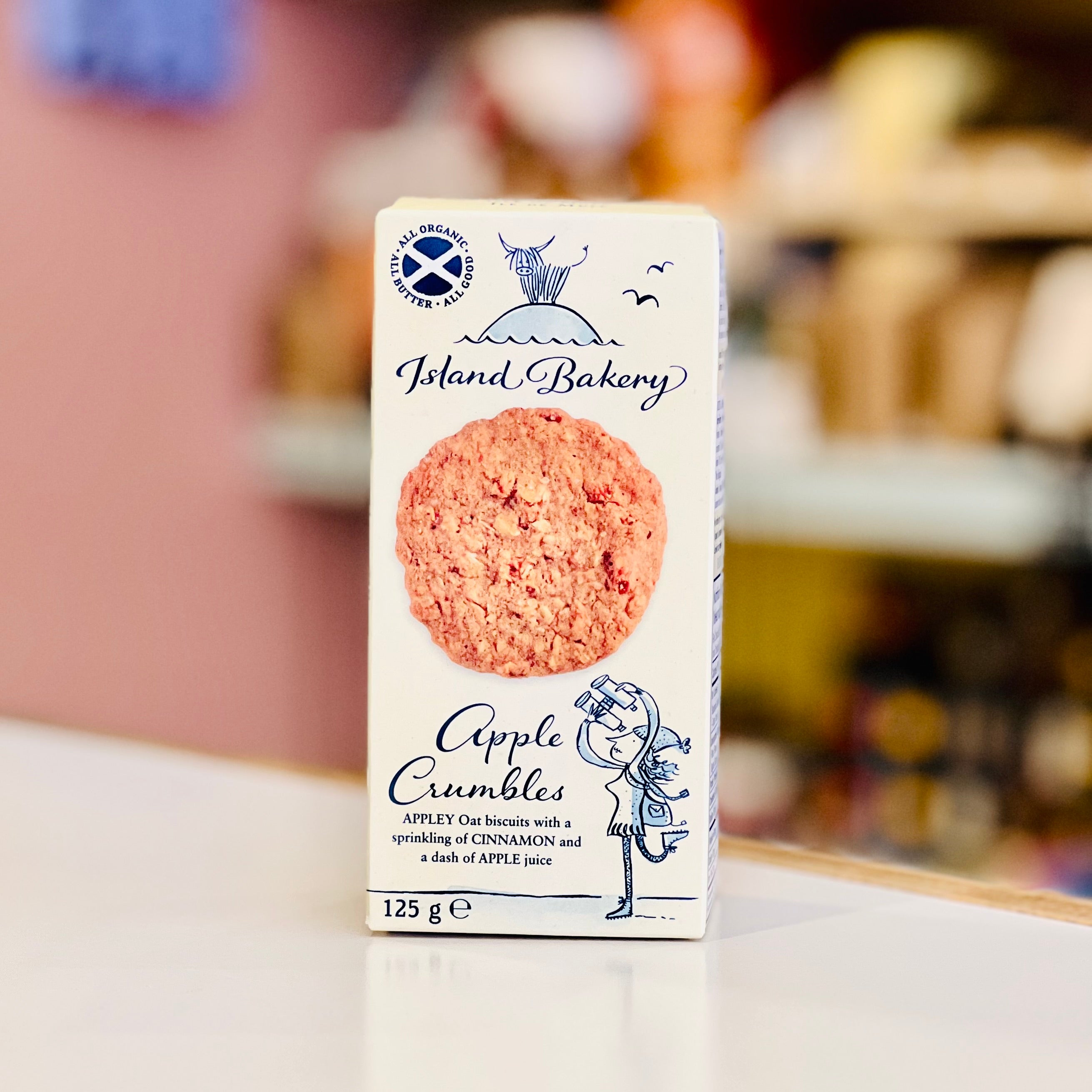 Box of Island Bakery Apple Crumbles on a white surface with a blurred background