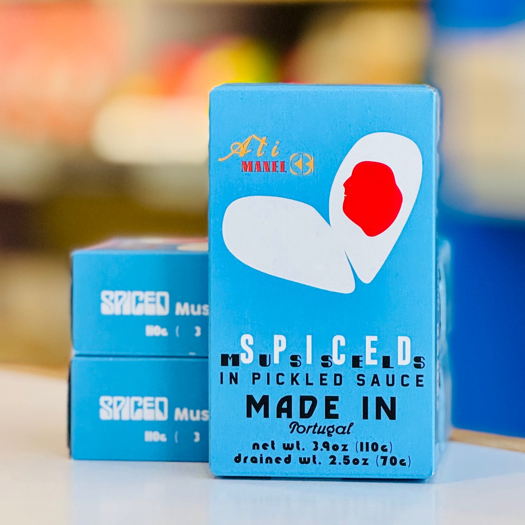 Blue box of 'Spiced Mussels in Pickled Sauce' with a red heart logo on a blurred background