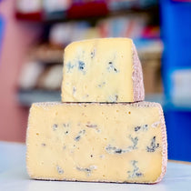 Two blocks of blue cheese stacked on top of each other with a blurred background
