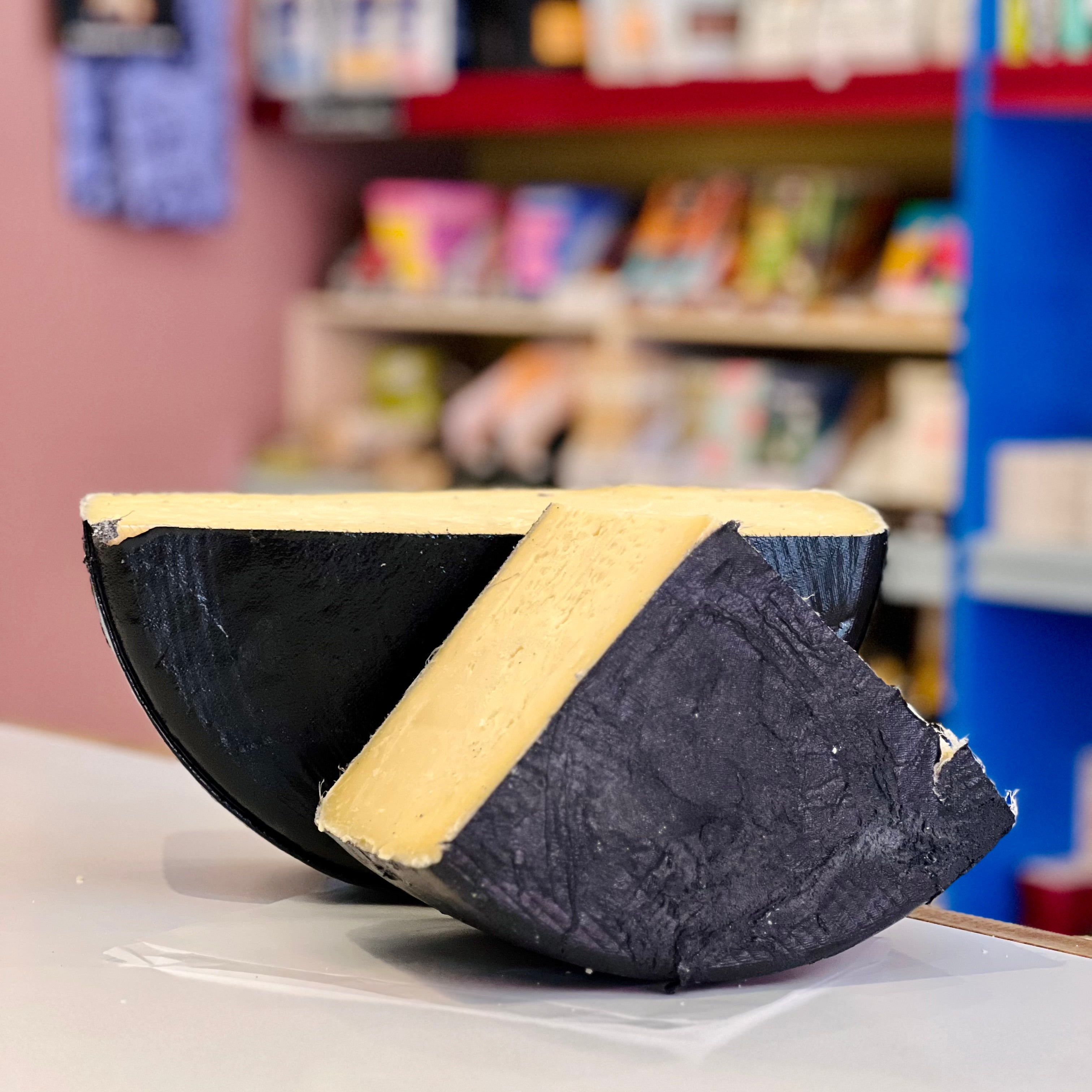 Black and yellow object on a white surface with a blurred background of books and shelves.