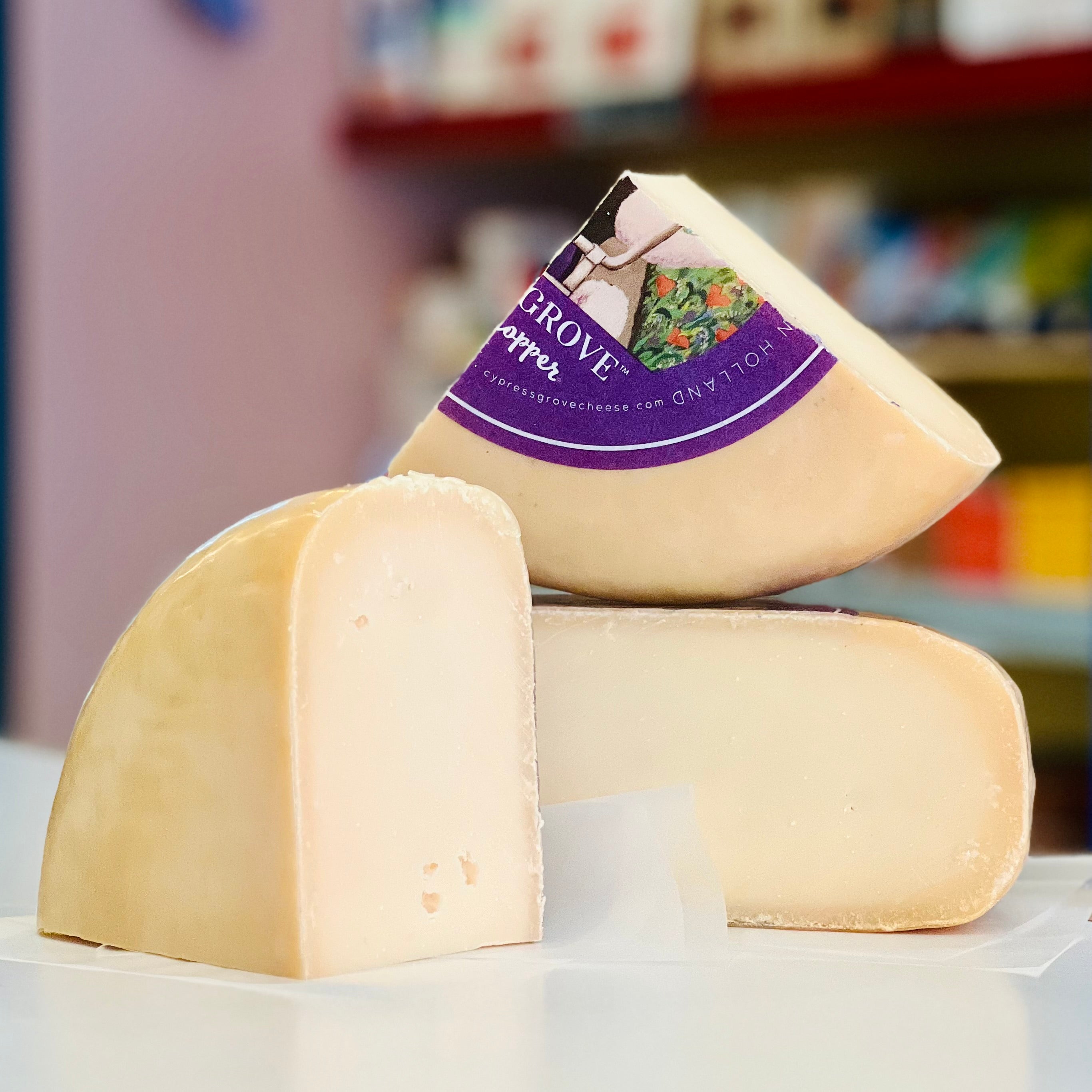 Two wedges of cheese with a 'Grove' label on a white surface.