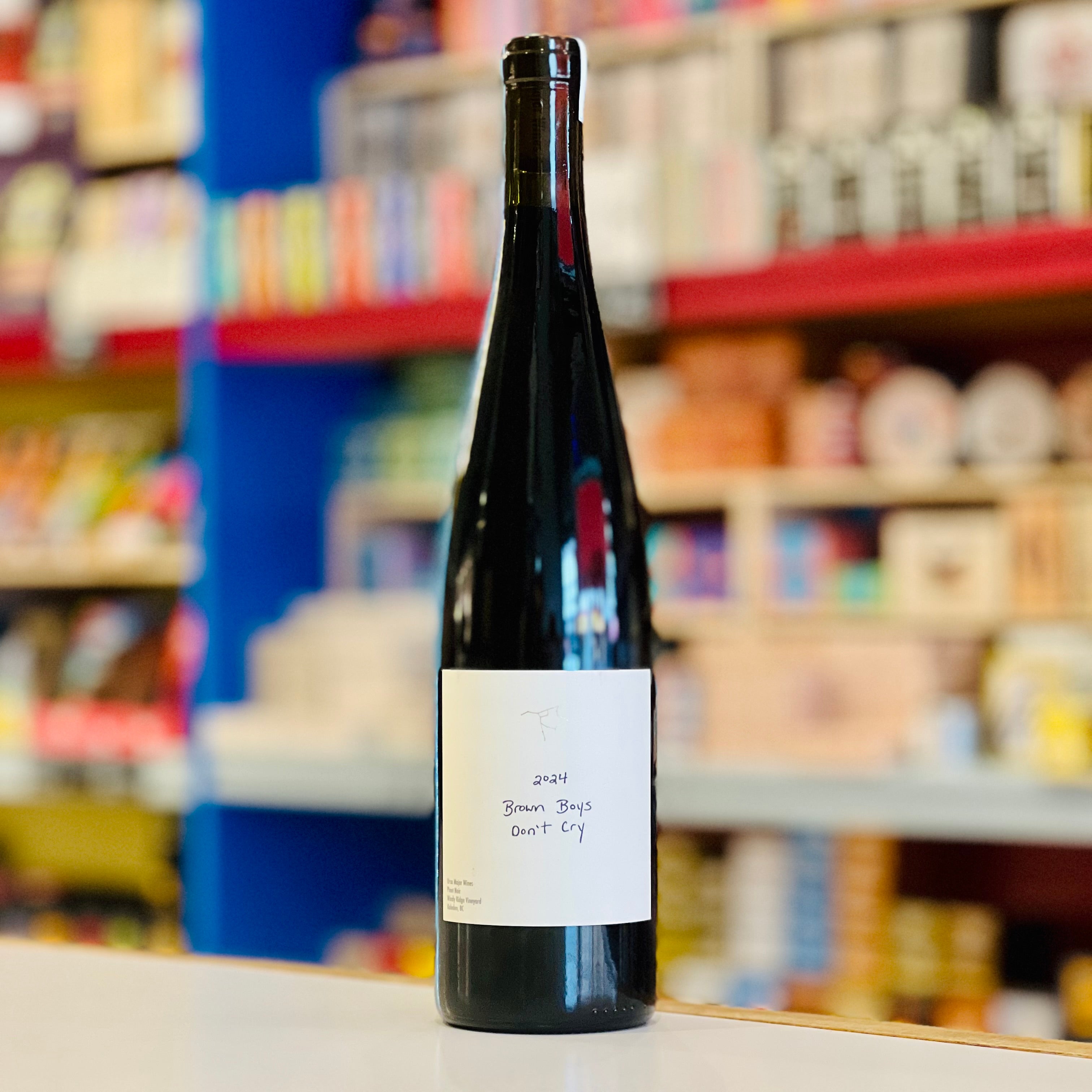 Wine bottle labeled '2018 Brown Boys Don't Cry' on a shelf in a store.