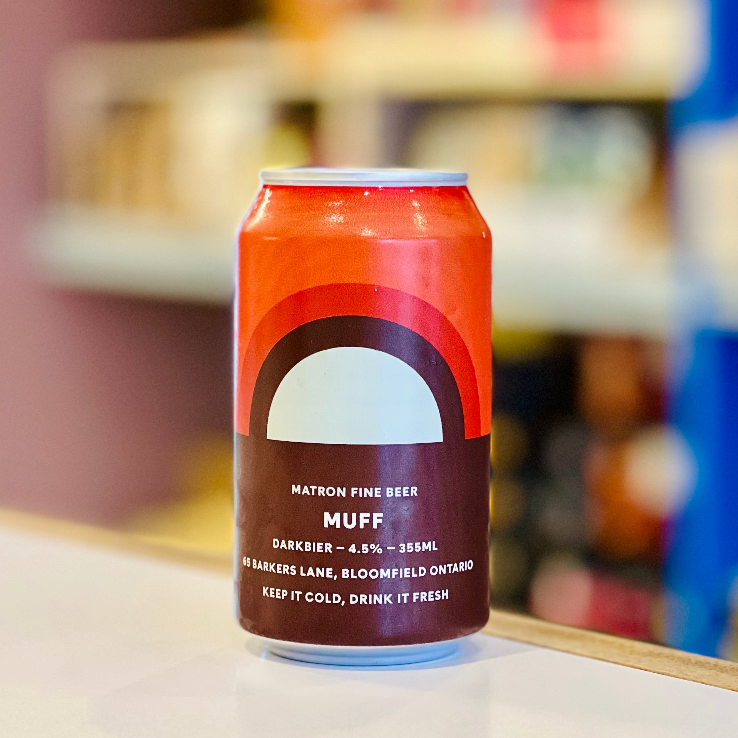 Beer can with a red and brown label on a blurred background