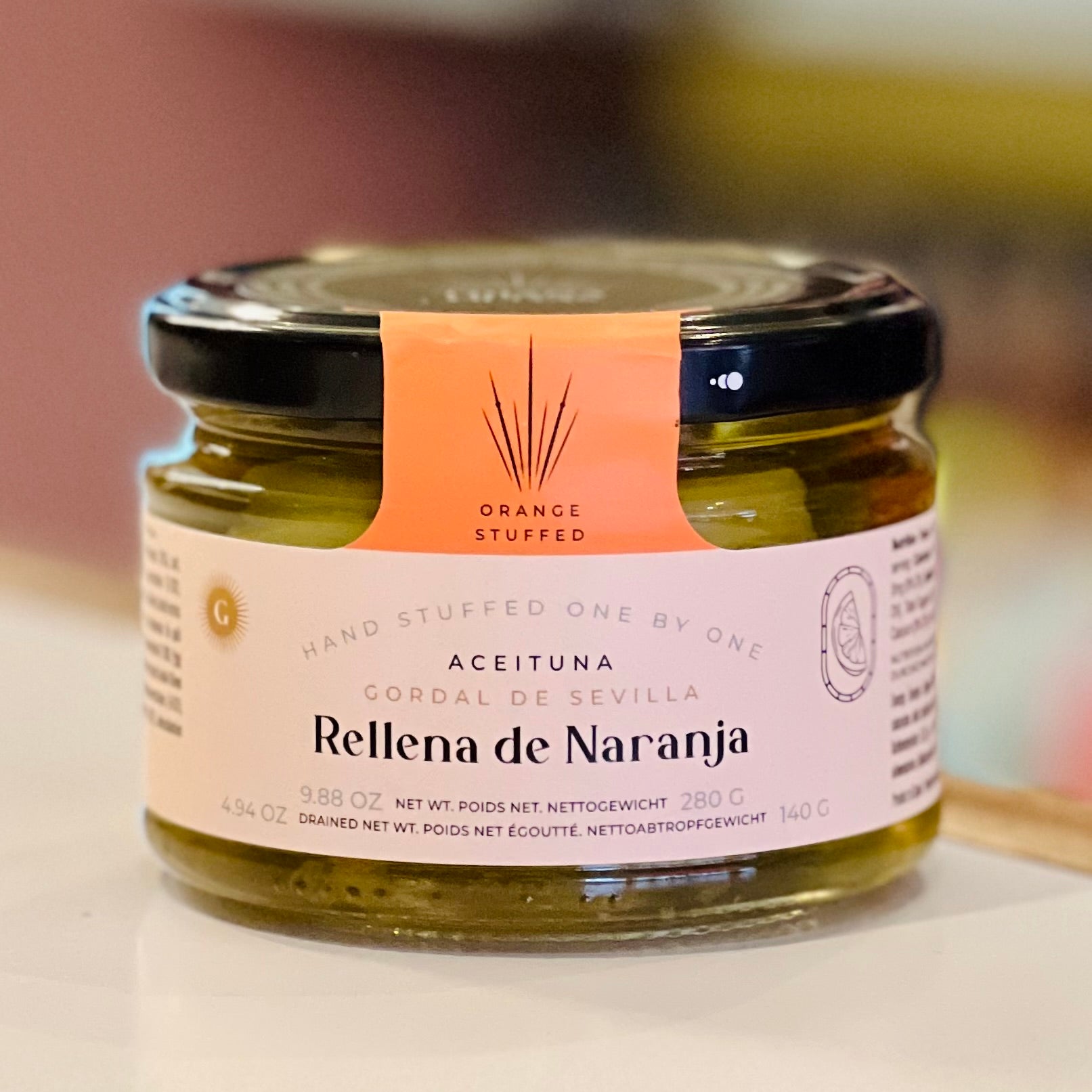 Jar of 'Rellena de Naranja' with a pink label on a blurred background