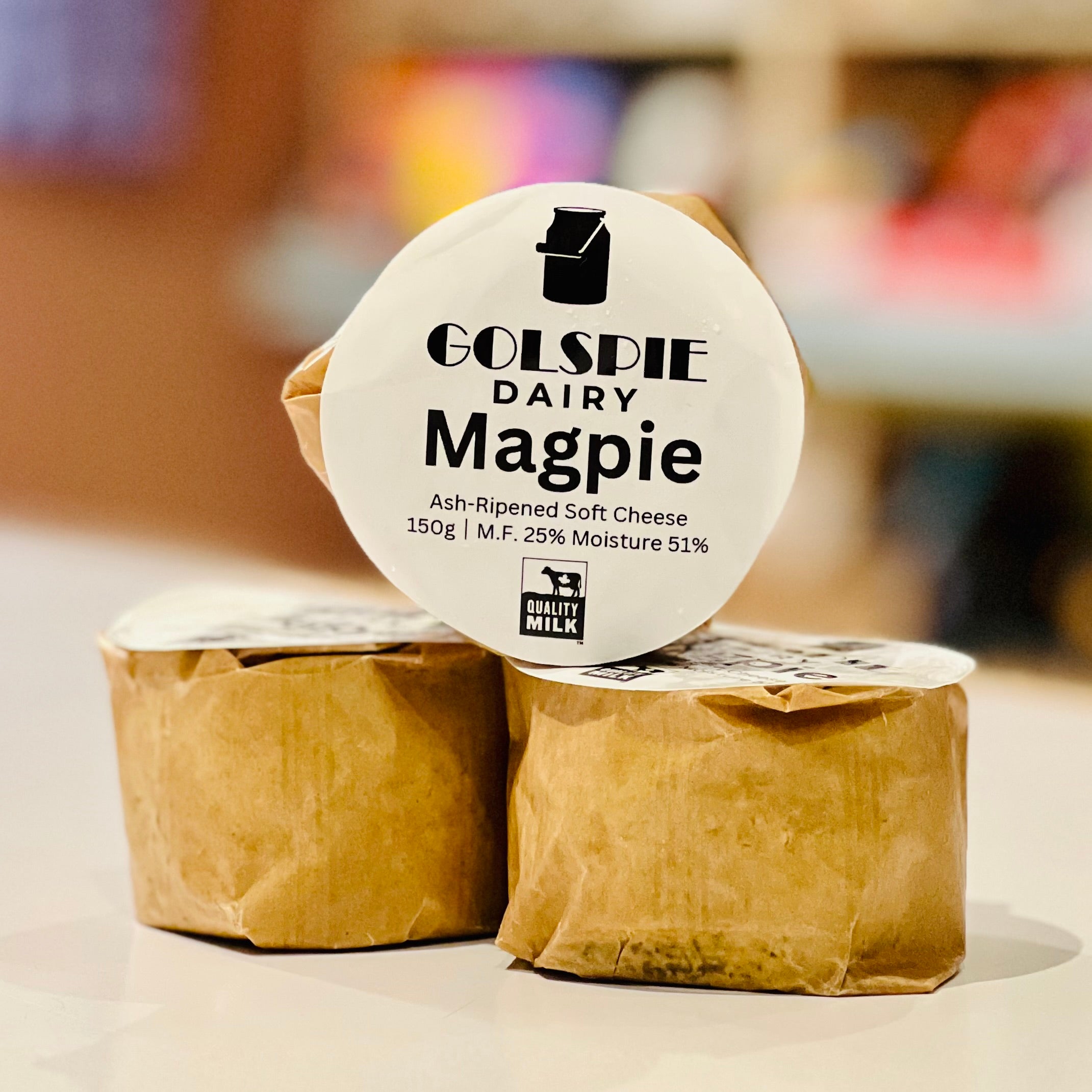 Two wrapped soft cheeses with a Golspie Dairy Magpie label on a blurred background