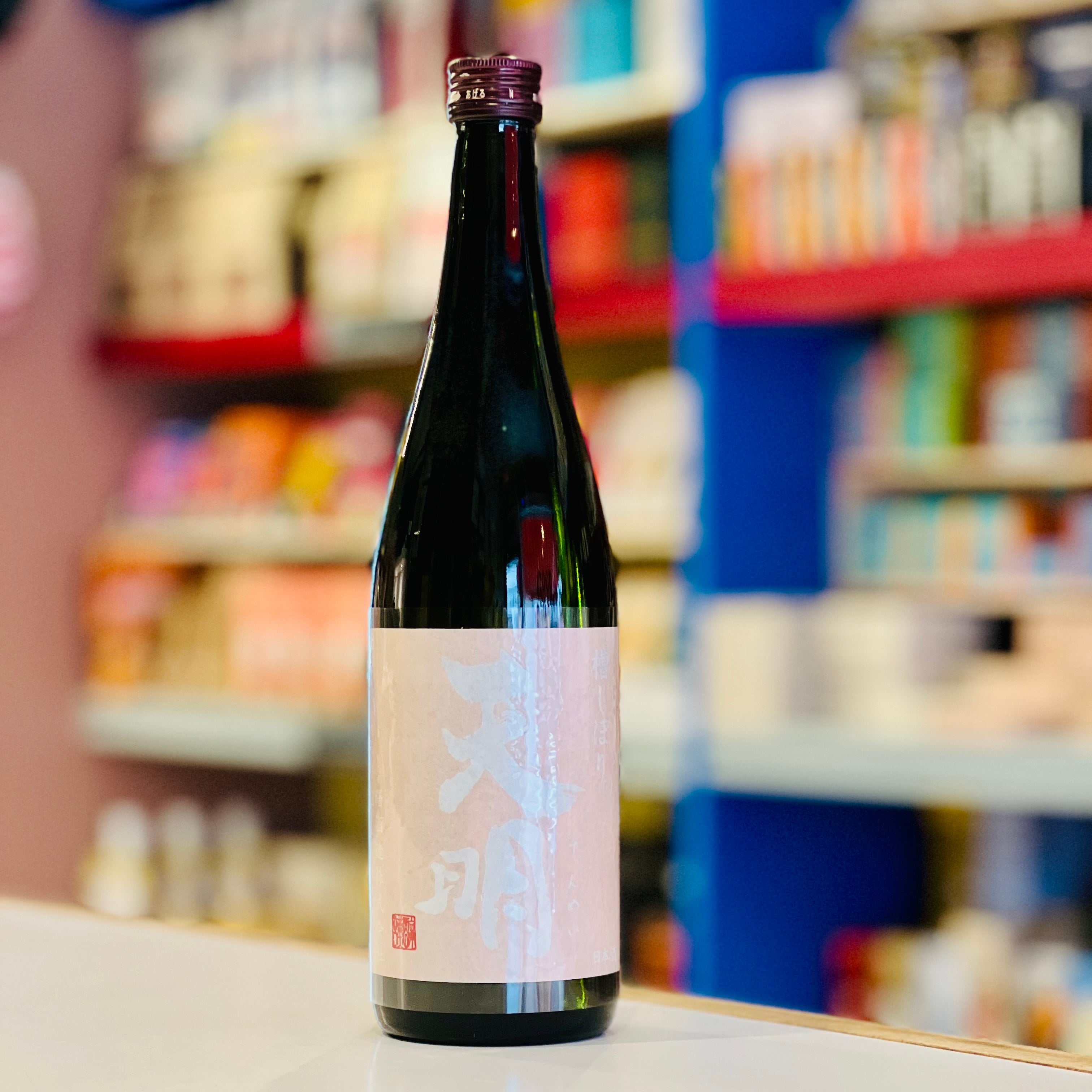 Bottle of sake on a counter with shelves in the background