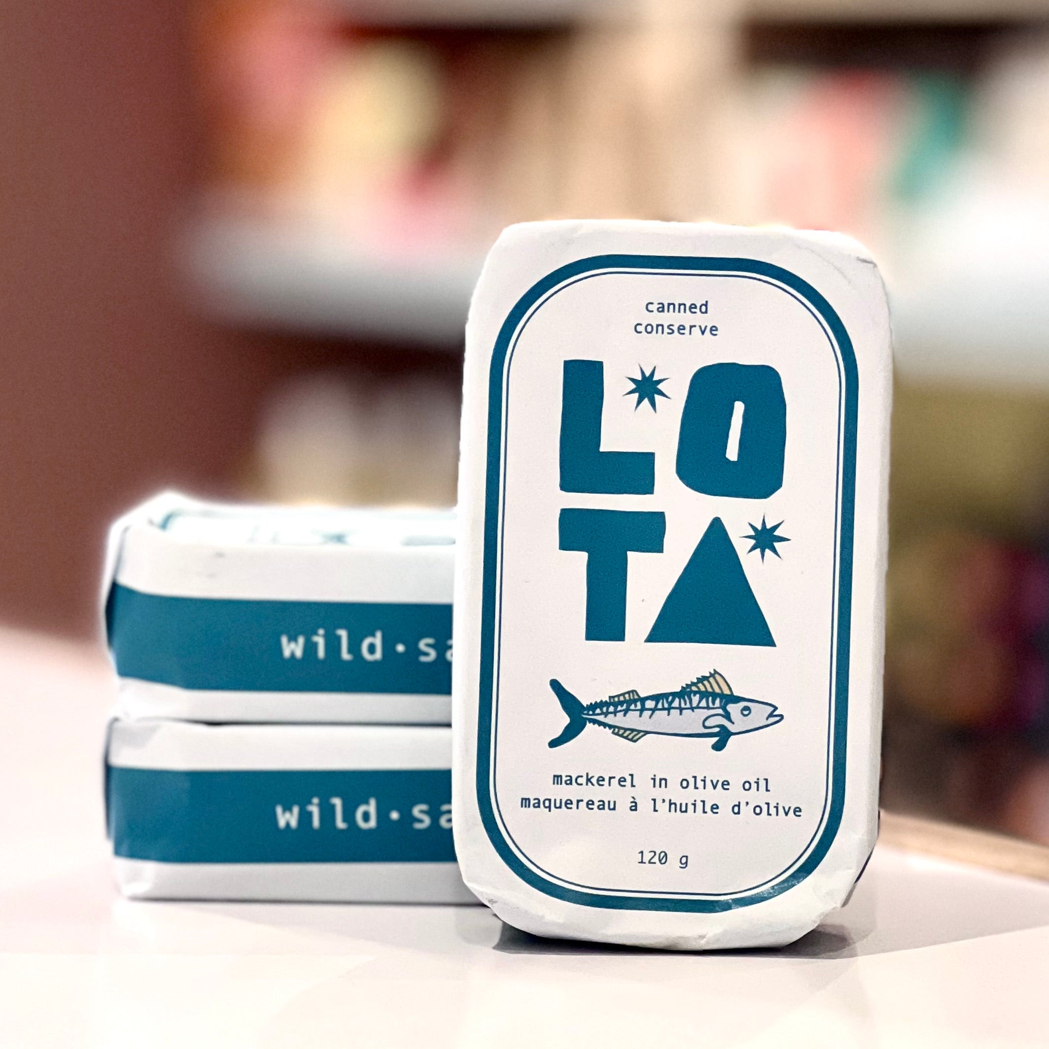 Canned conserve packaging with 'Lota' branding on a blurred background