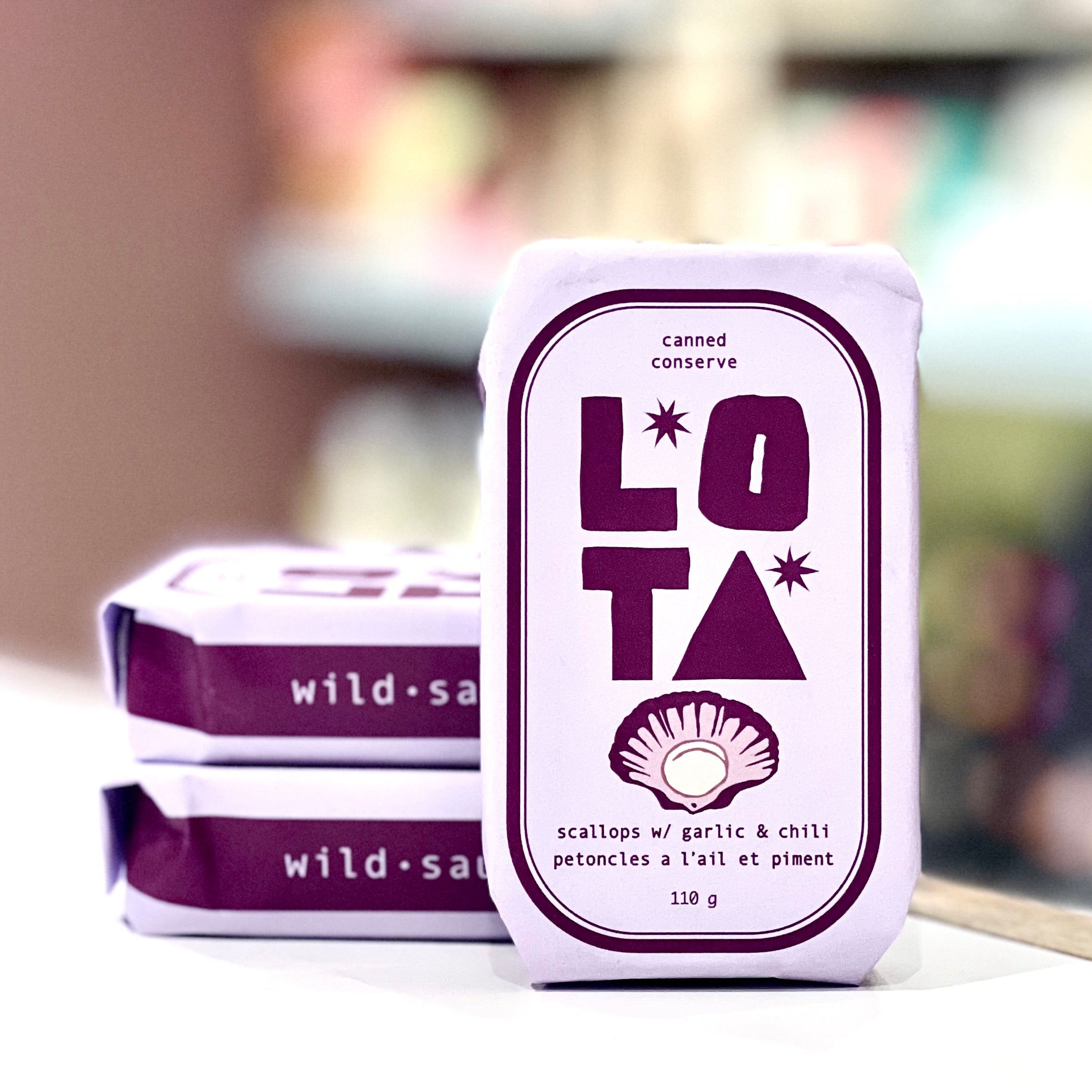 Canned food packaging with 'LOTA' branding on a blurred background