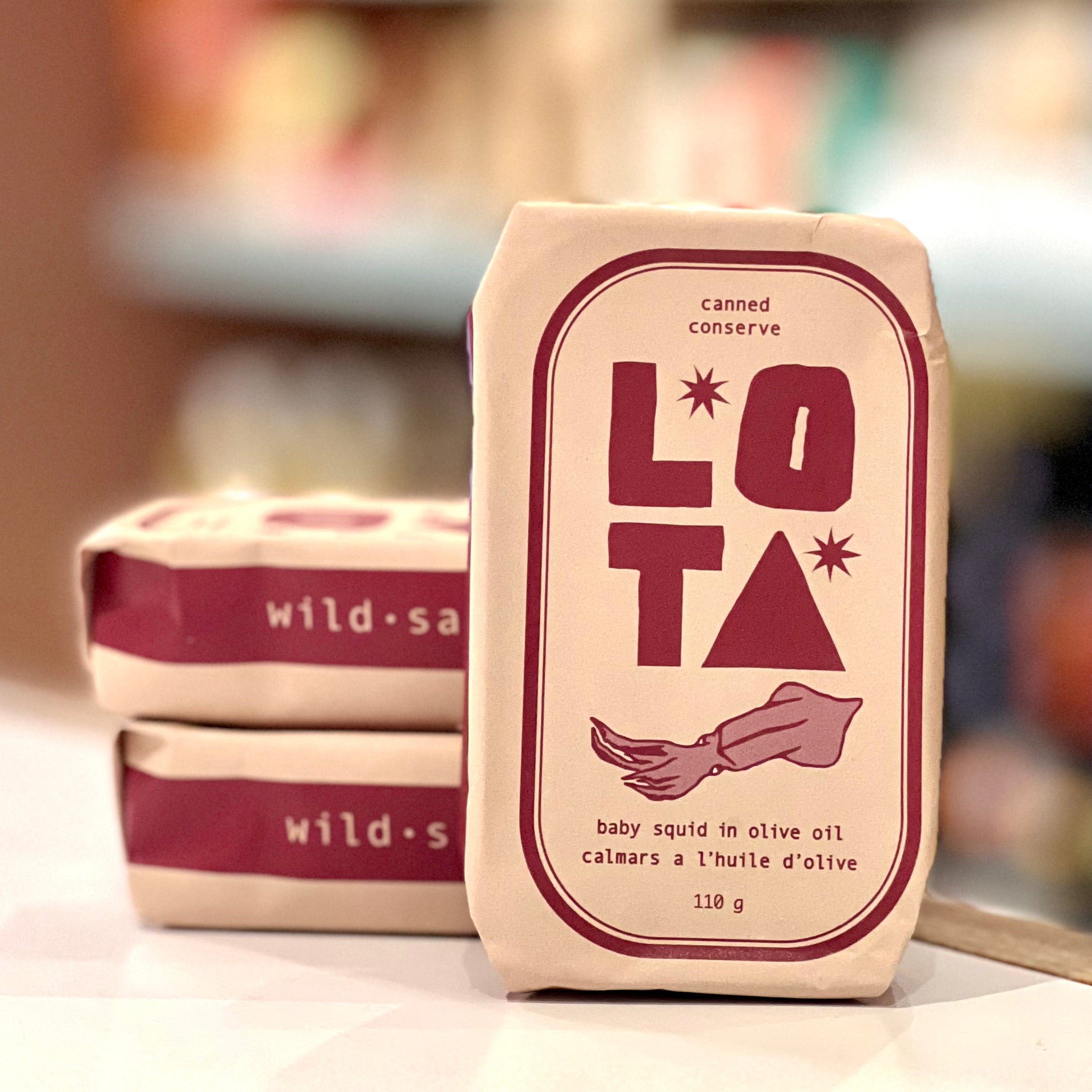 Canned conserve packaging with 'LOTA' branding on a blurred background