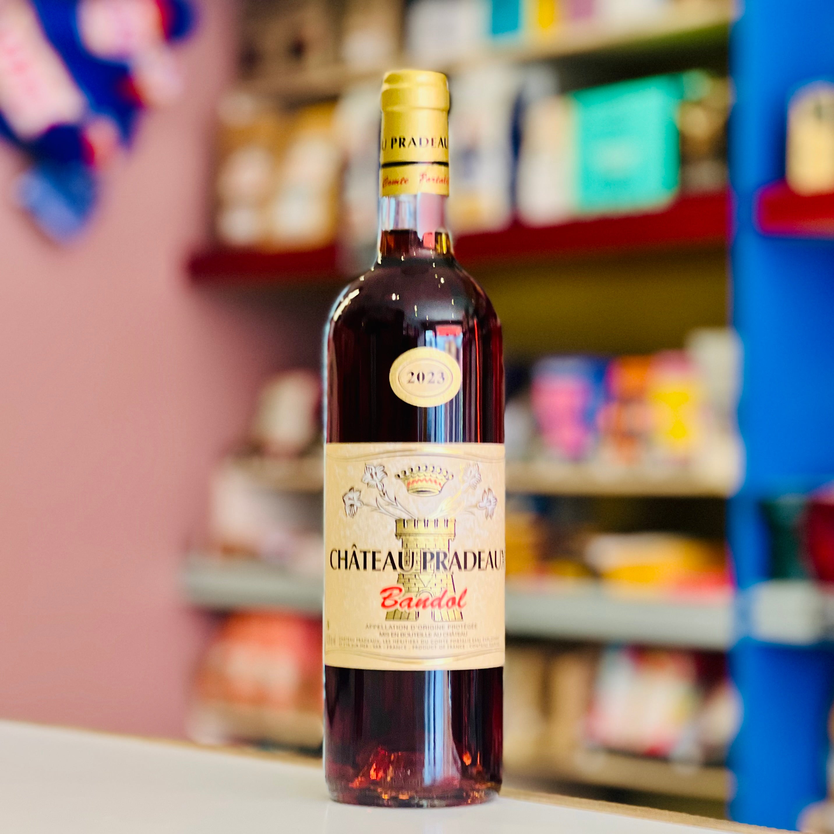 Bottle of Château Pradeau rose on a shelf with blurred store background