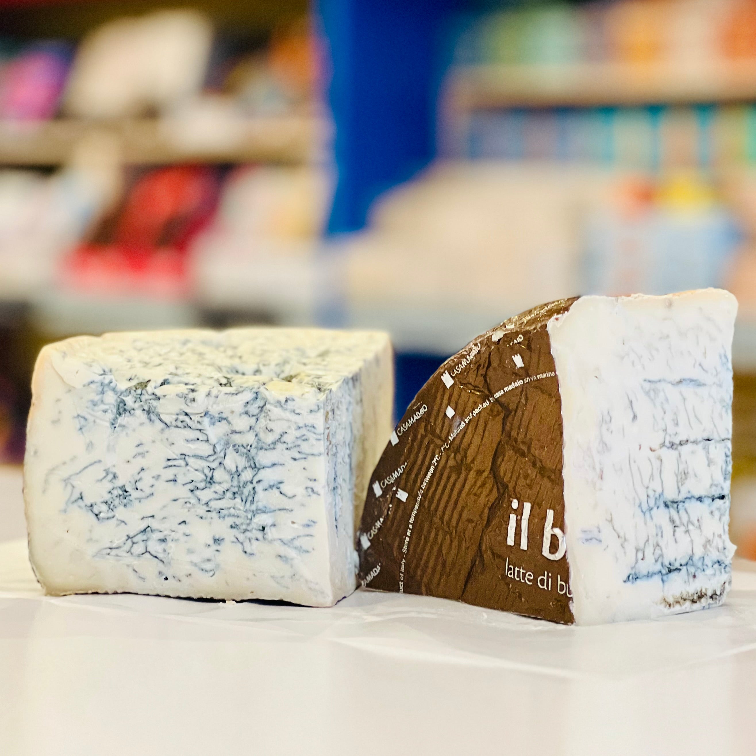 Two blocks of cheese with one labeled 'il b' on a white surface.