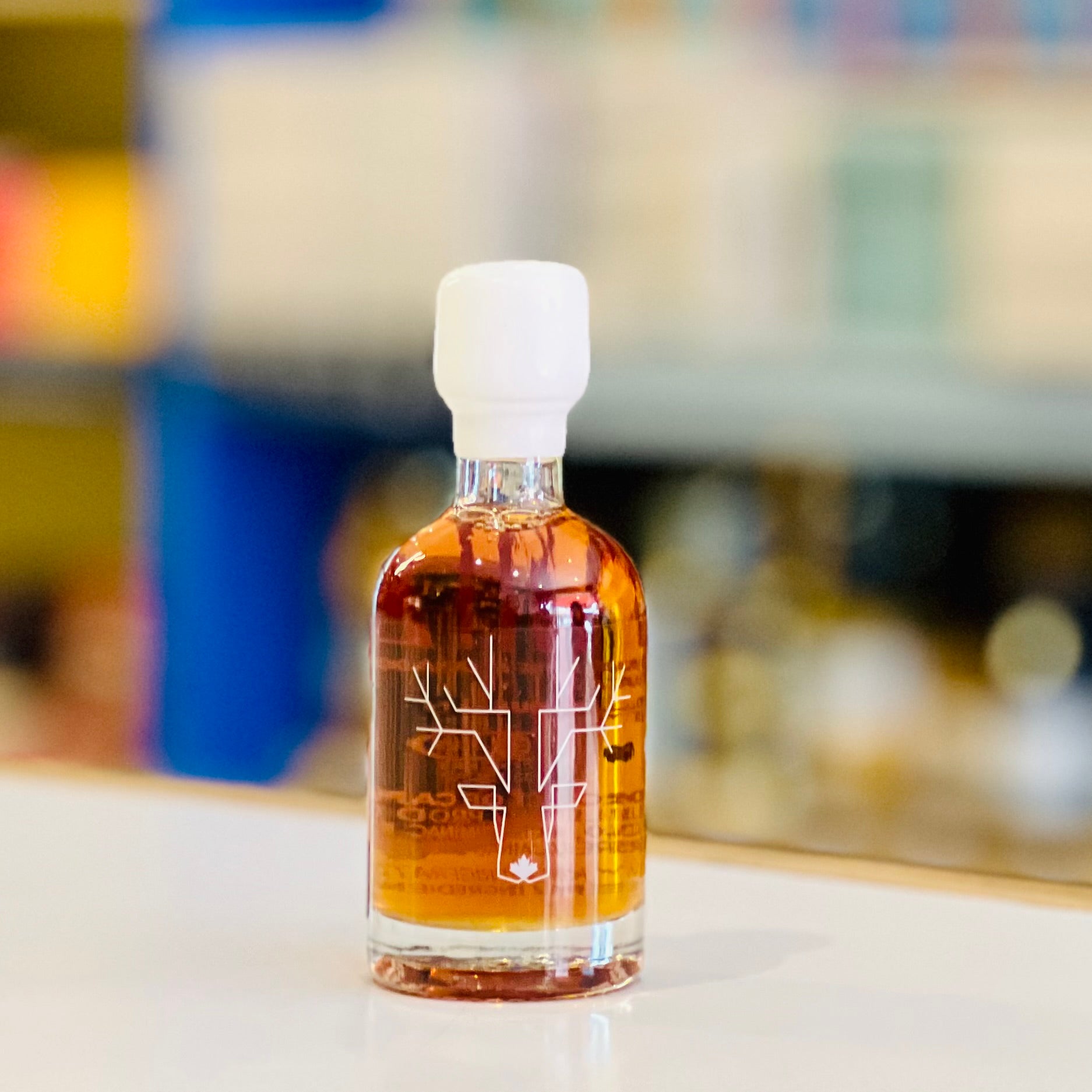 Bottle of amber liquid with a white cap on a blurred background