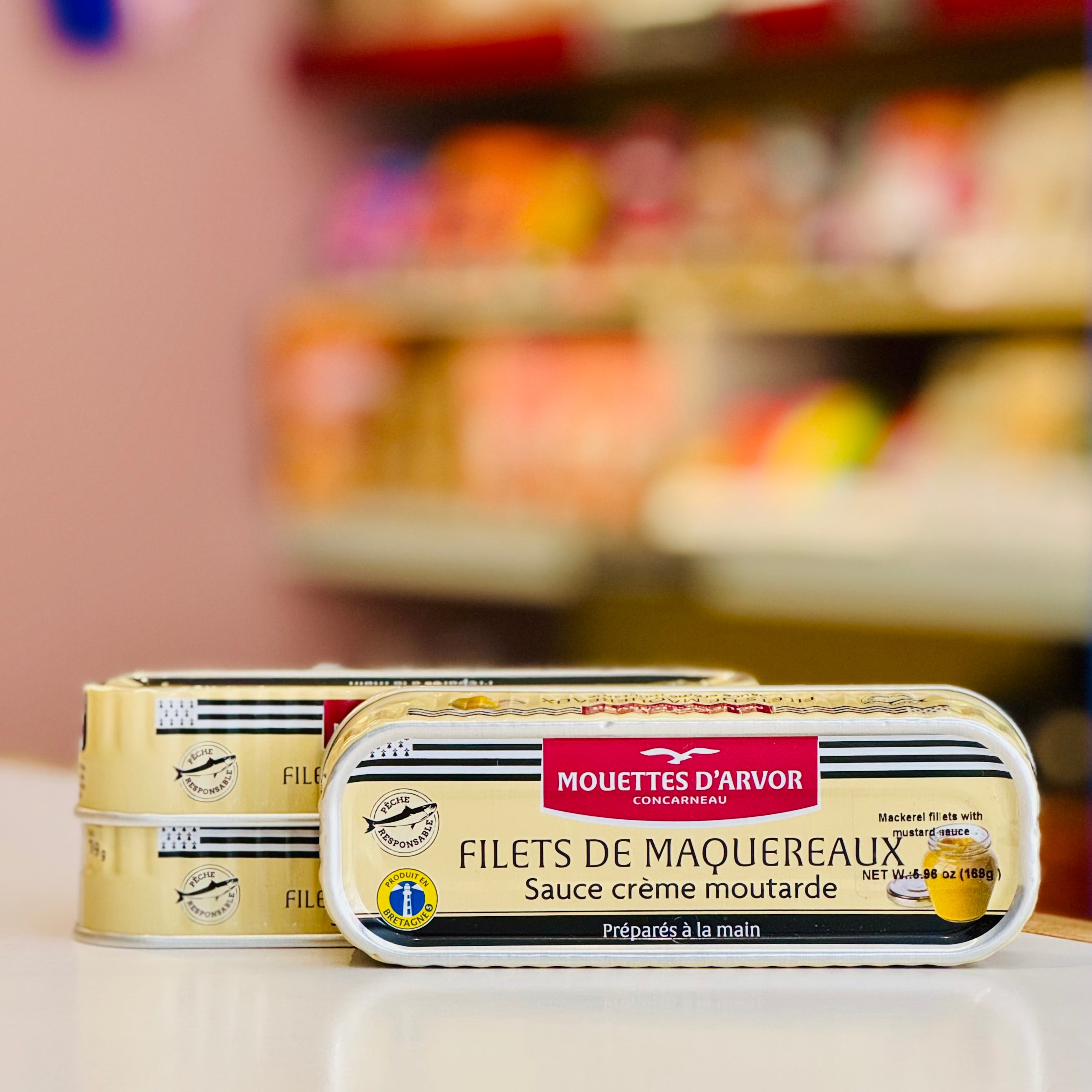 Mouettes d'Arvor filets de maquereaux with mustard sauce packaging on a blurred supermarket shelf background.