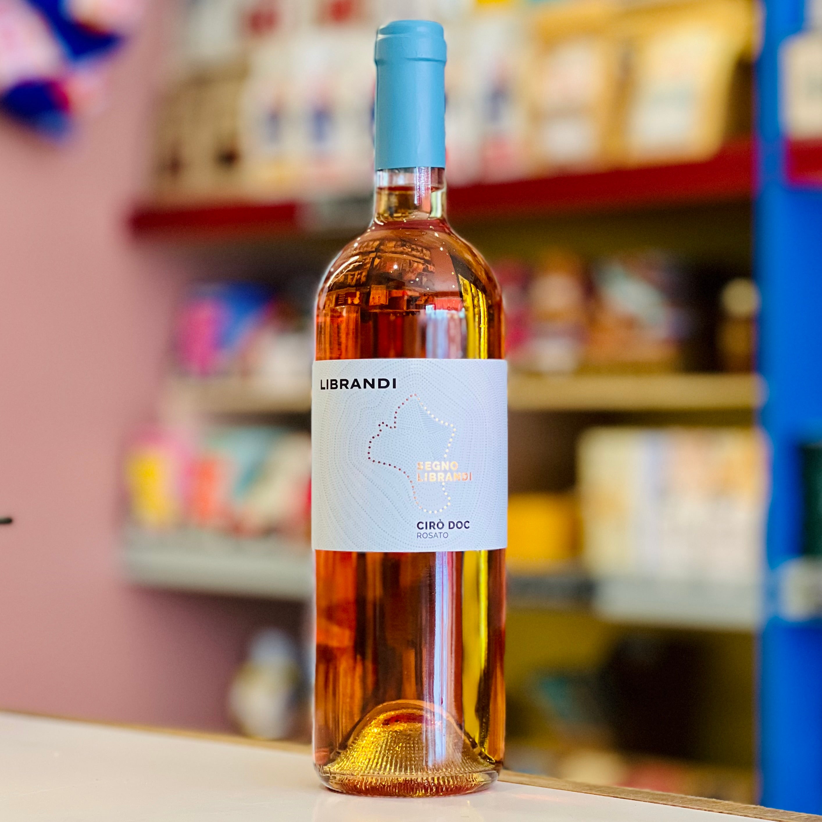 Bottle of Librandi wine with a blue label on a shelf in a store.