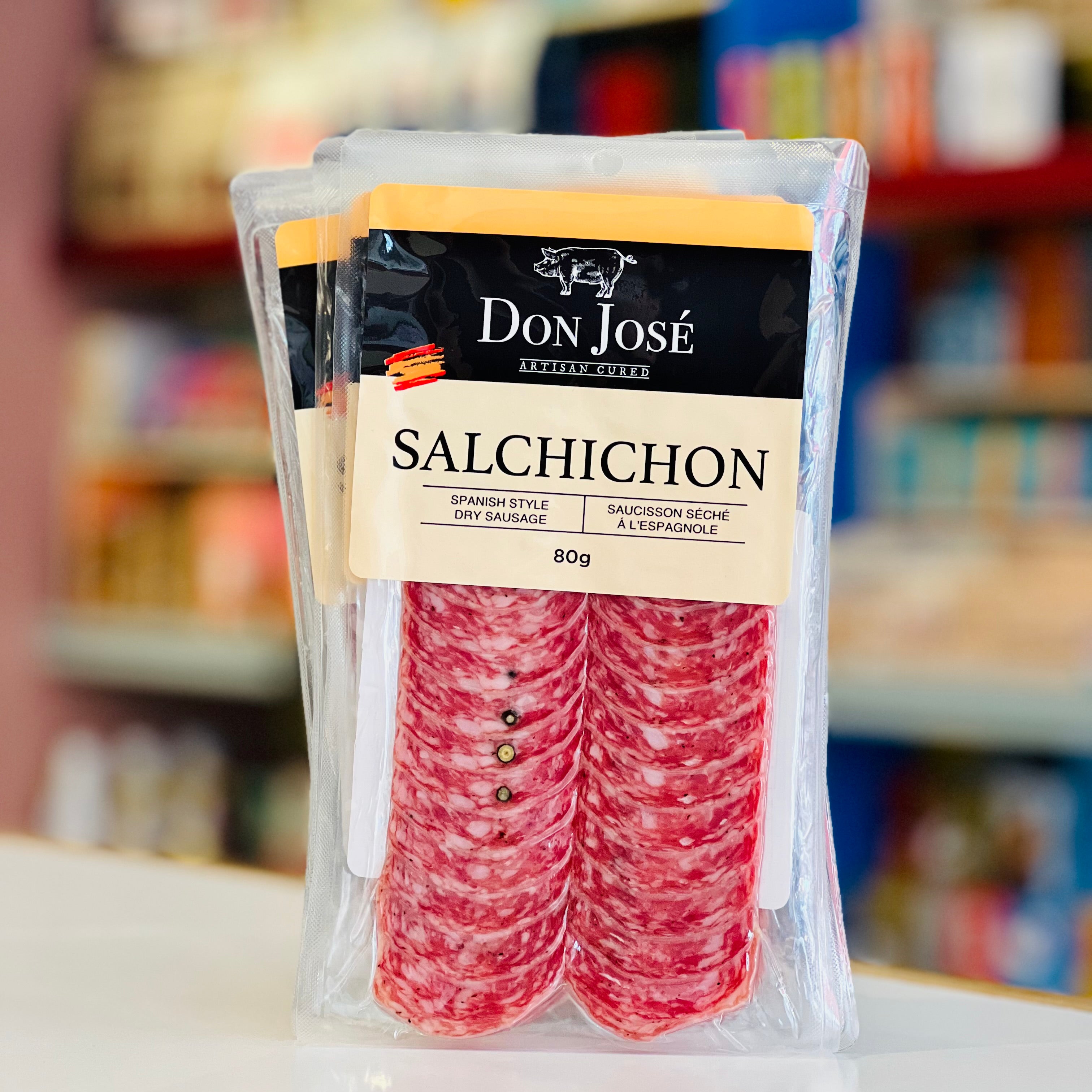 Packaged salchichon with Don Jose branding on a blurred store shelf background