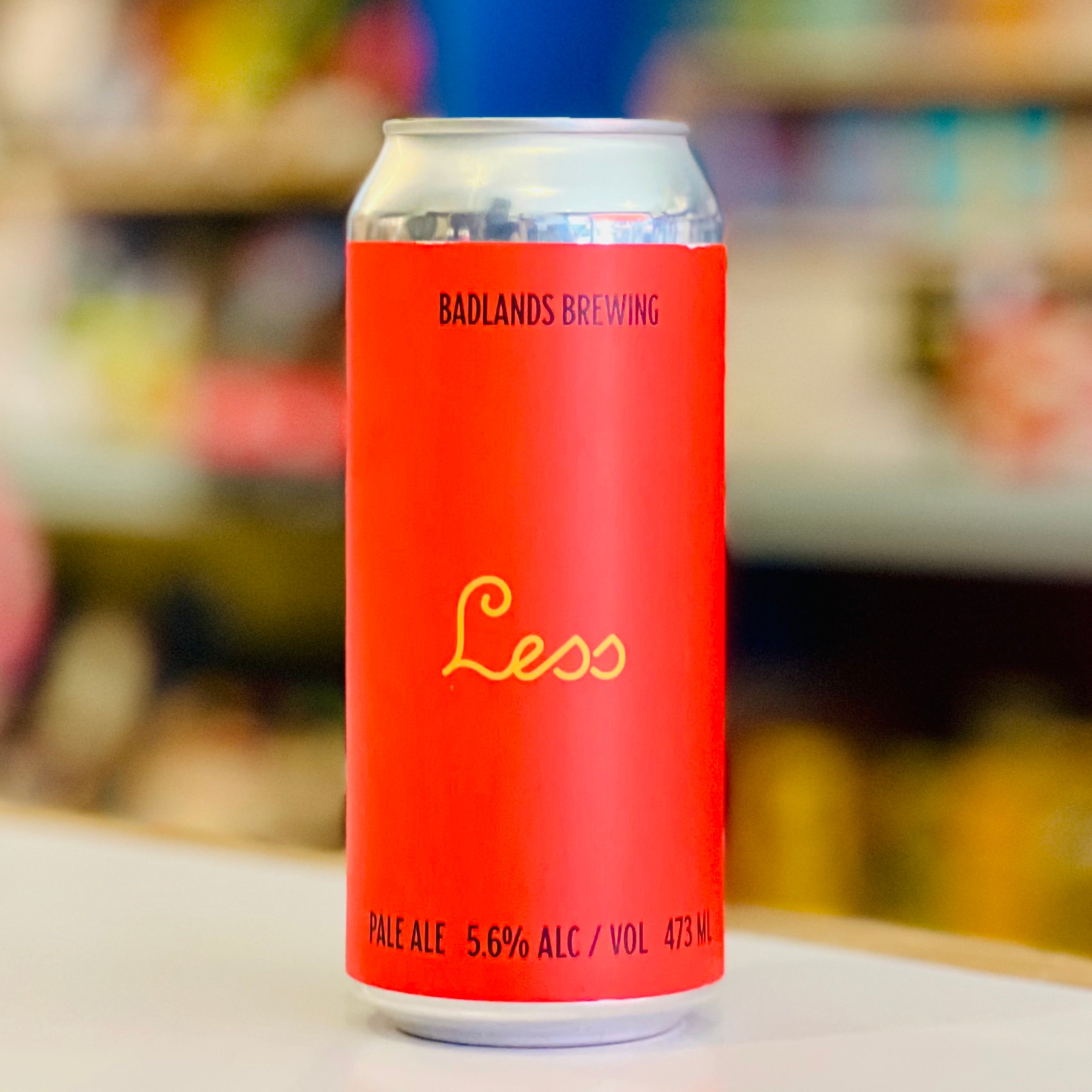 Red beer can with 'Badlands Brewing' branding on a blurred background