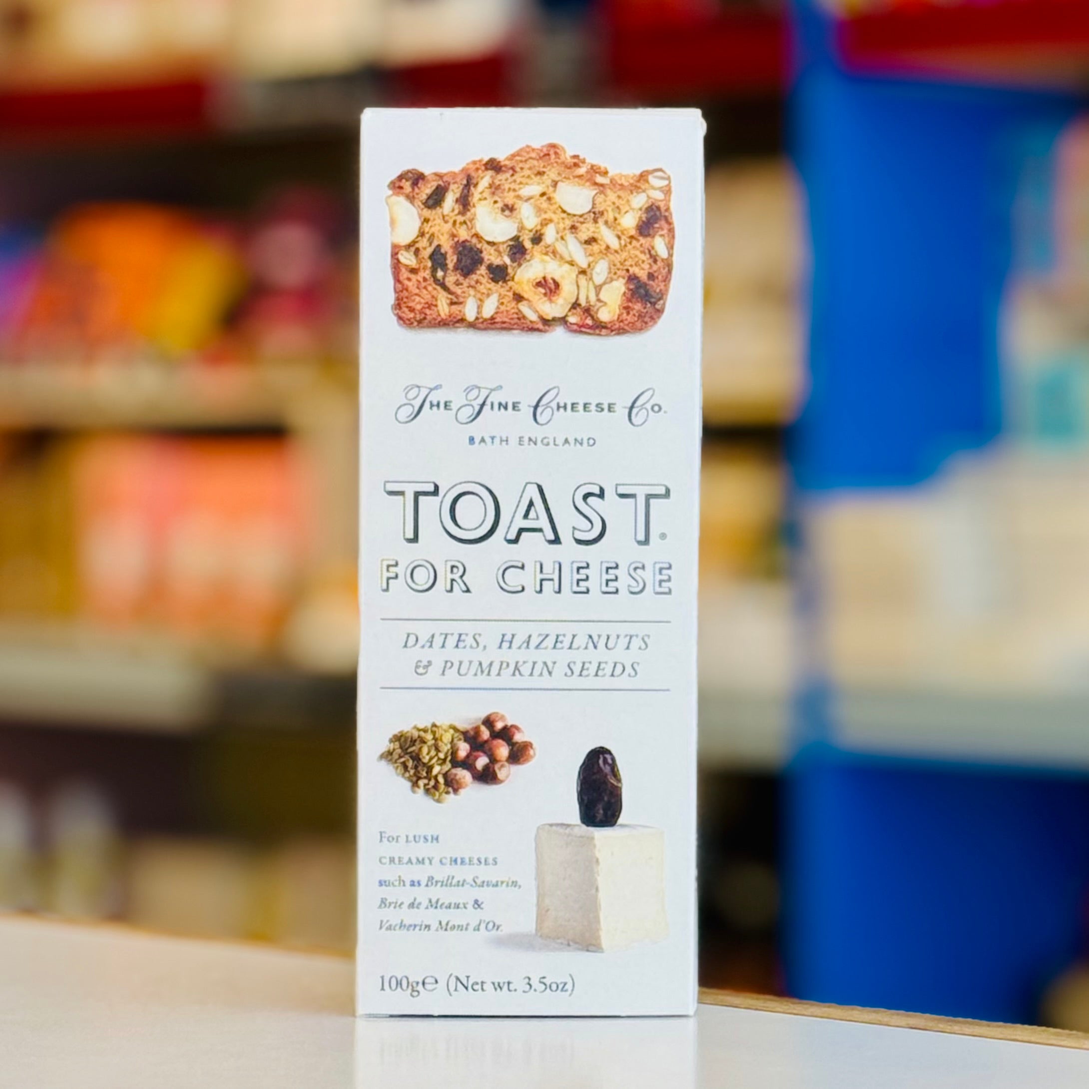 Box of 'Toast for Cheese' with ingredients on a blurred store shelf background