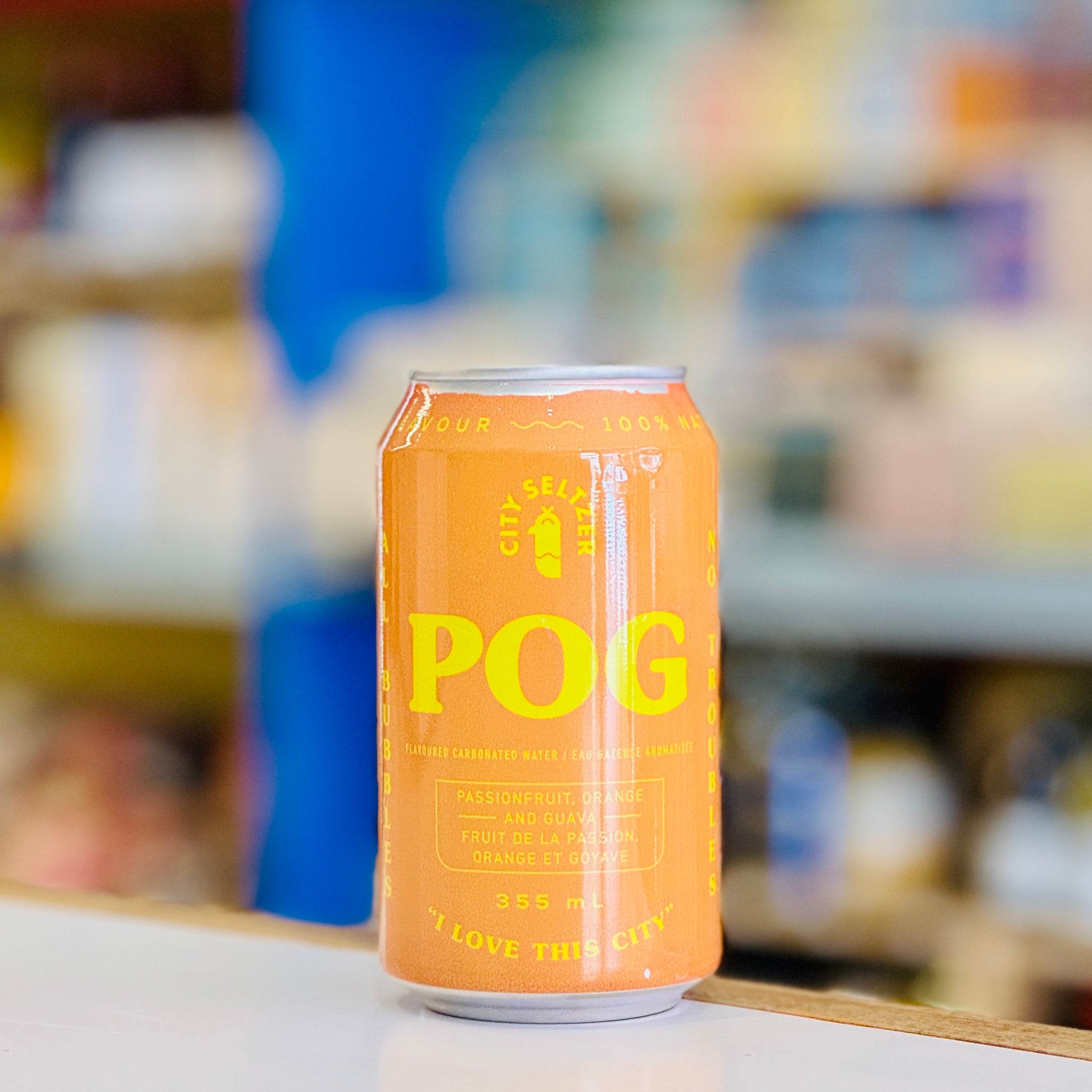 Orange can of POG with a blurred store shelf in the background
