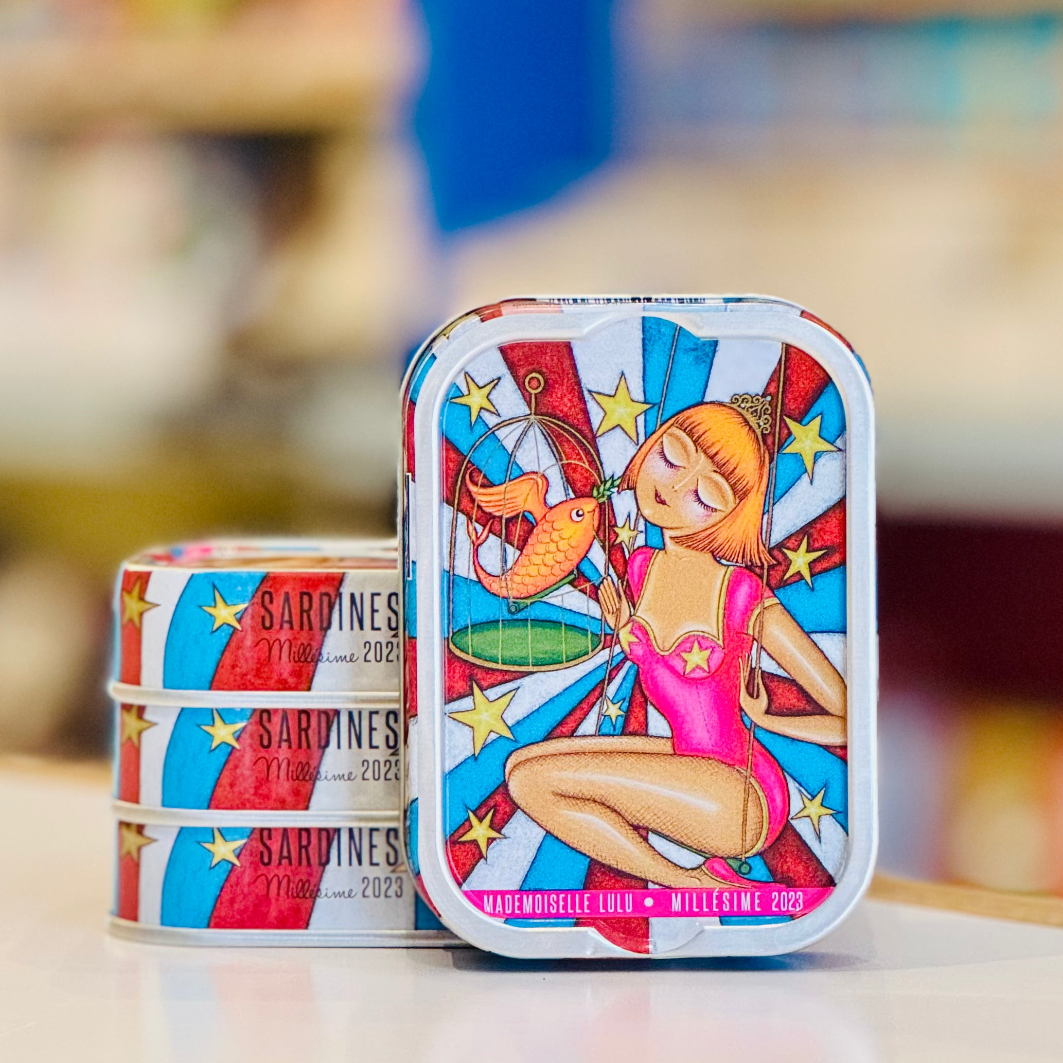 Decorative sardine tins with artistic designs on a blurred background