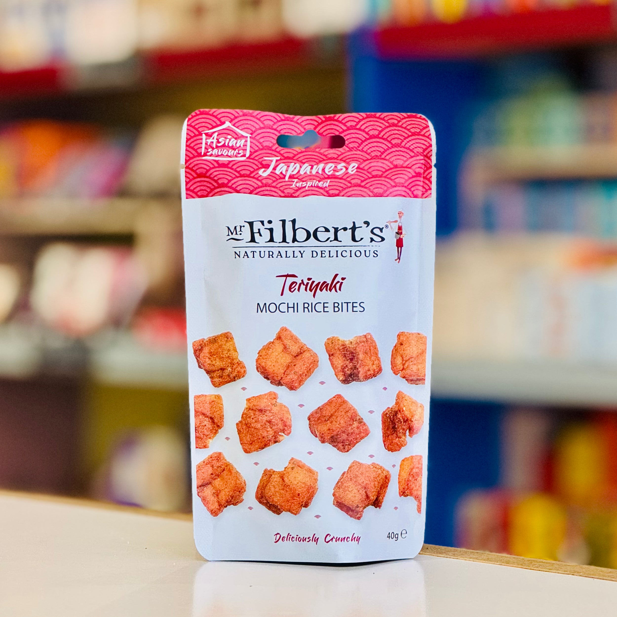 Packaging of Mr Filbert's Teriyaki Mochi Rice Bites on a blurred store shelf background