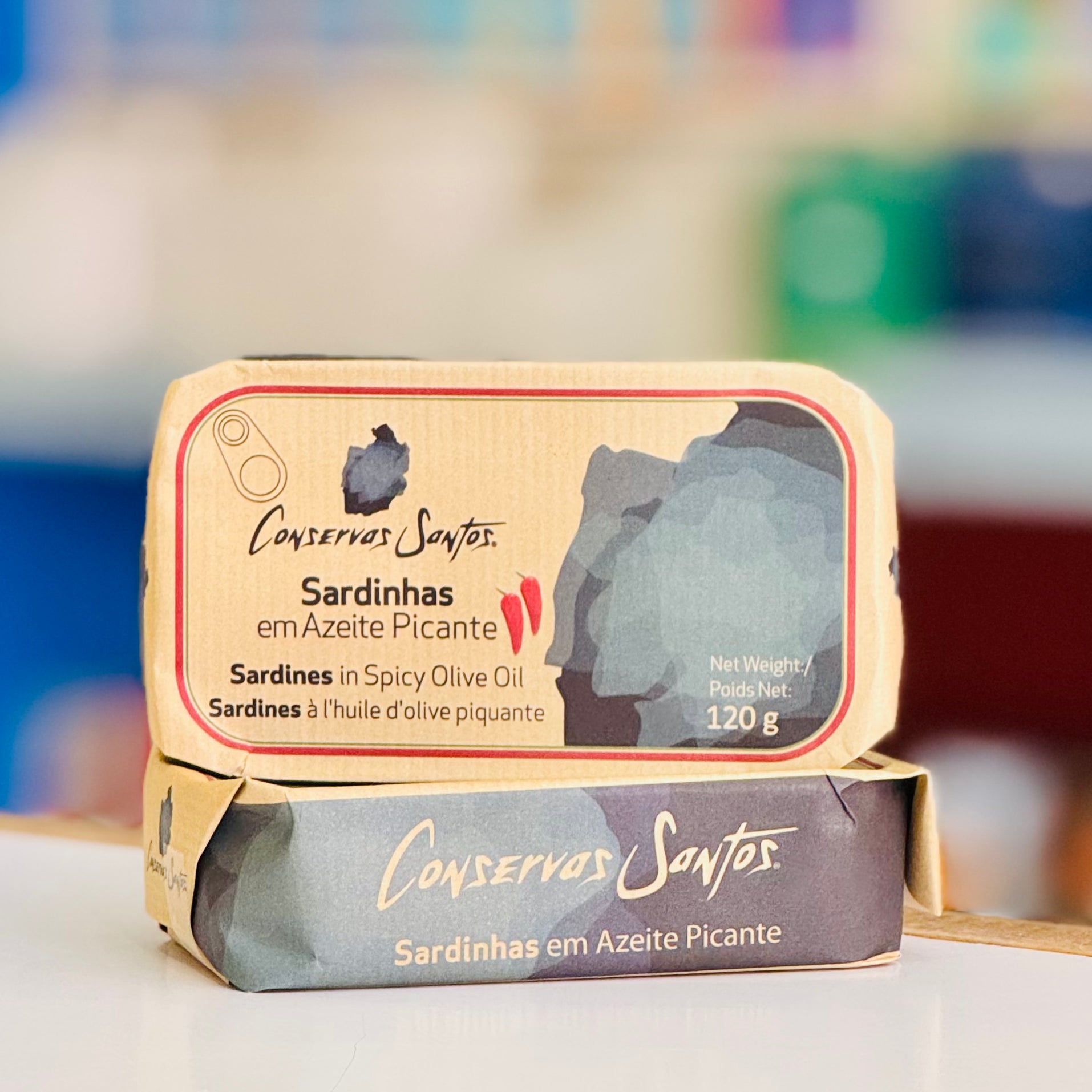 Two packages of Conservas Santos sardines in spicy olive oil on a blurred background