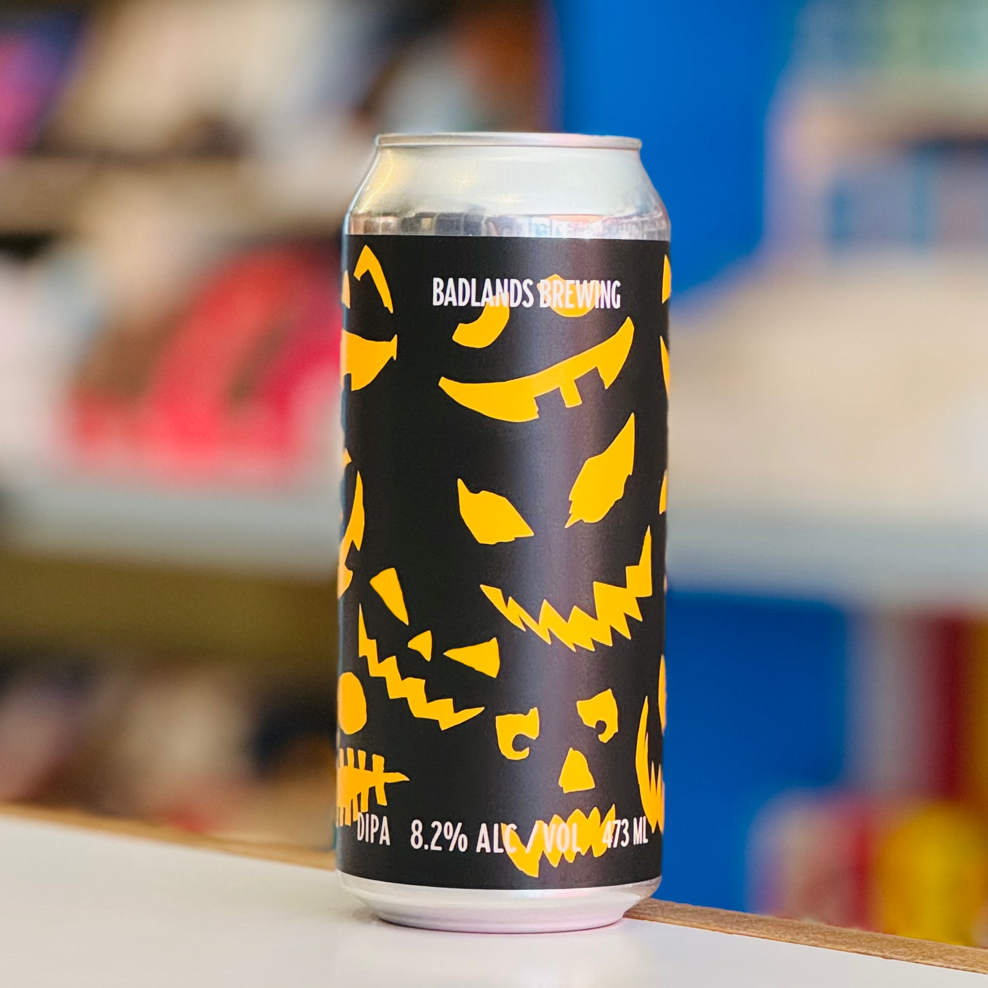 Beer can with yellow skull designs on a black background, featuring 'Badlands Brewing' branding.