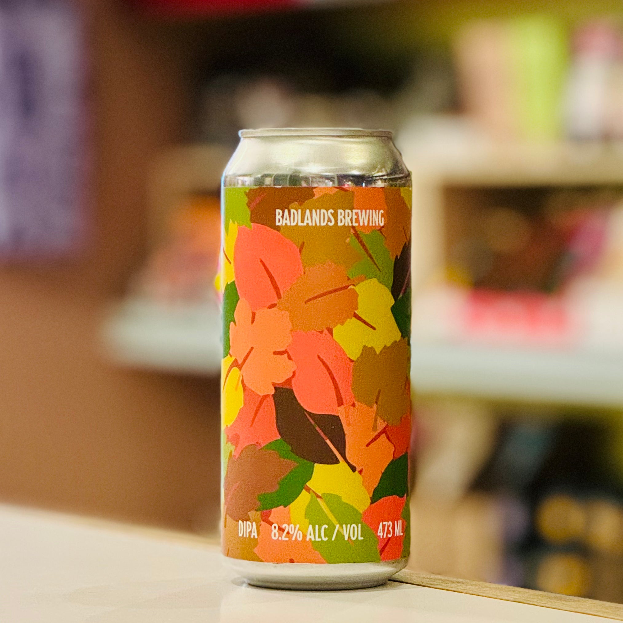 Colorful beer can with floral design on a blurred background