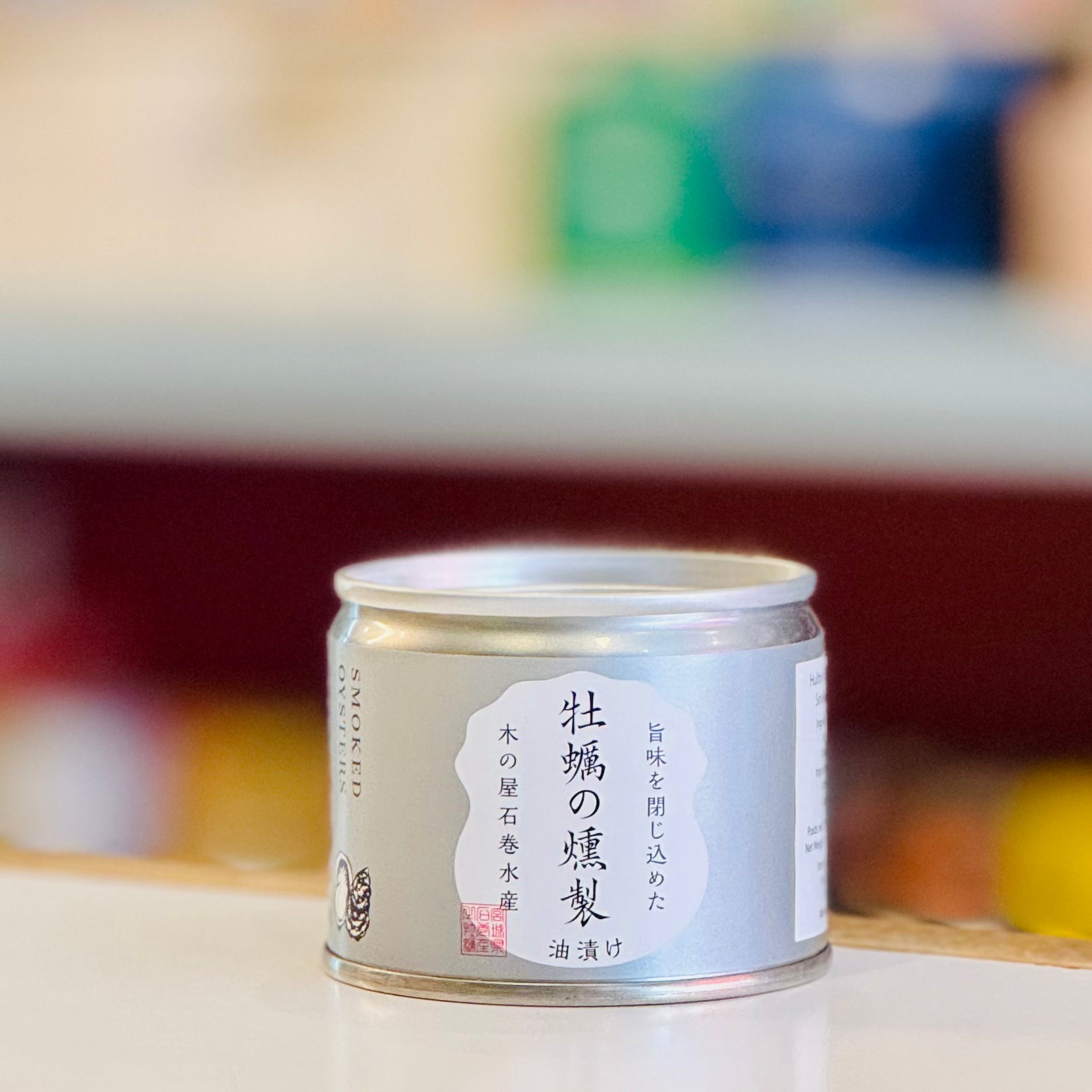 Canned oysters with Japanese script on a blurred background