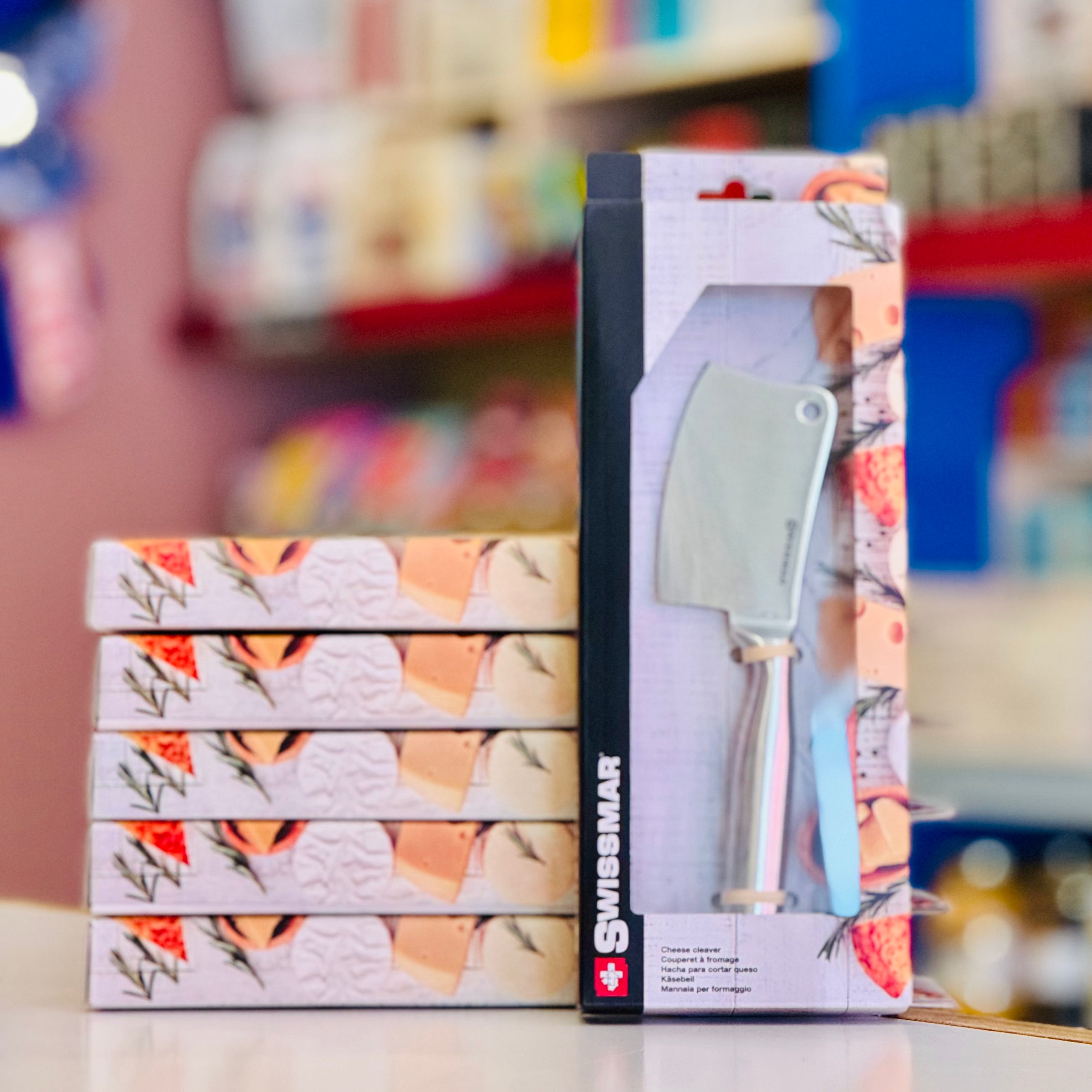 Packaged kitchen tool with floral design on a blurred store shelf background