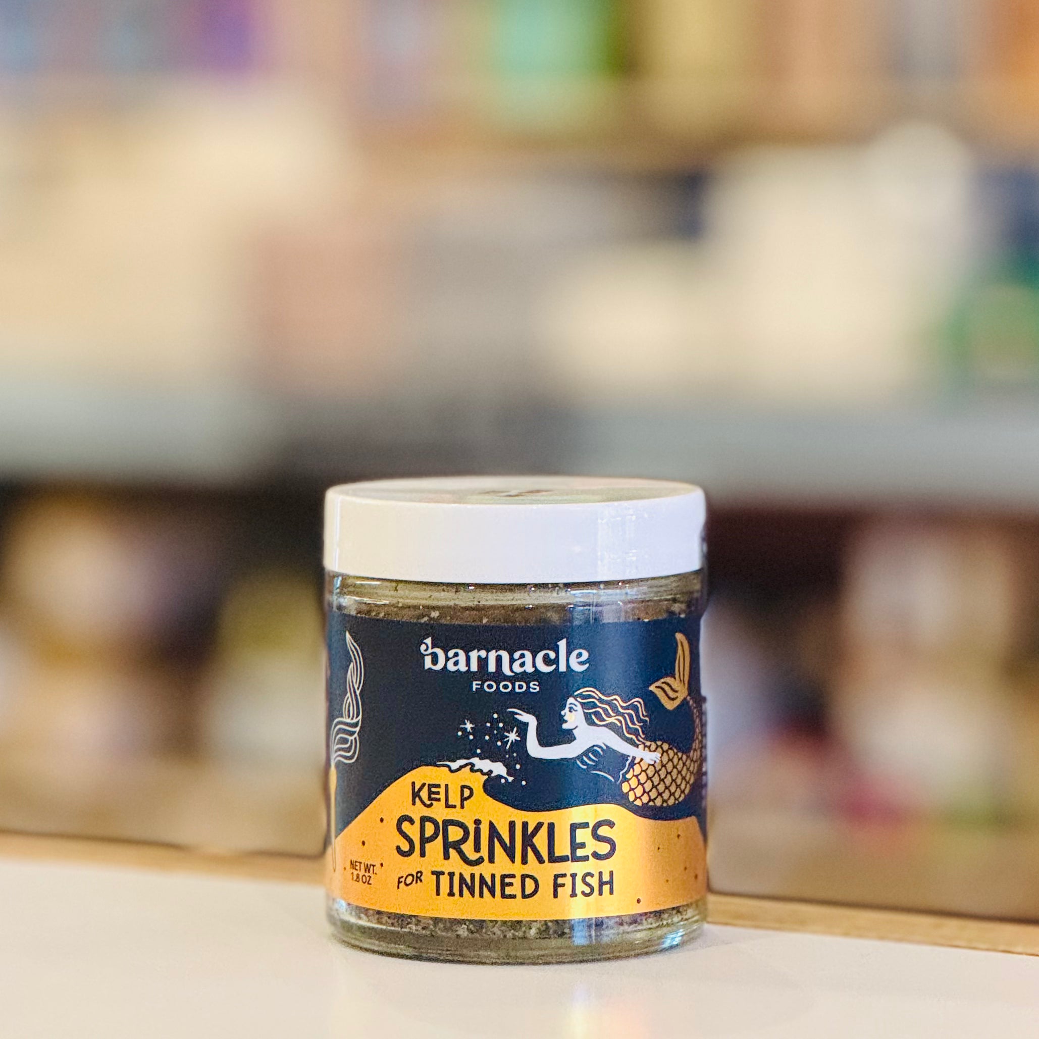 Jar of barnacle foods kelp sprinkles for tinned fish on a blurred background