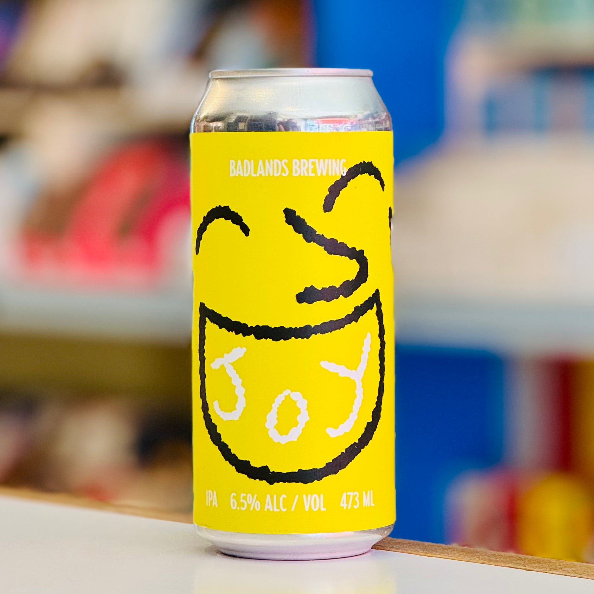 Yellow beer can with black and white design on a blurred background