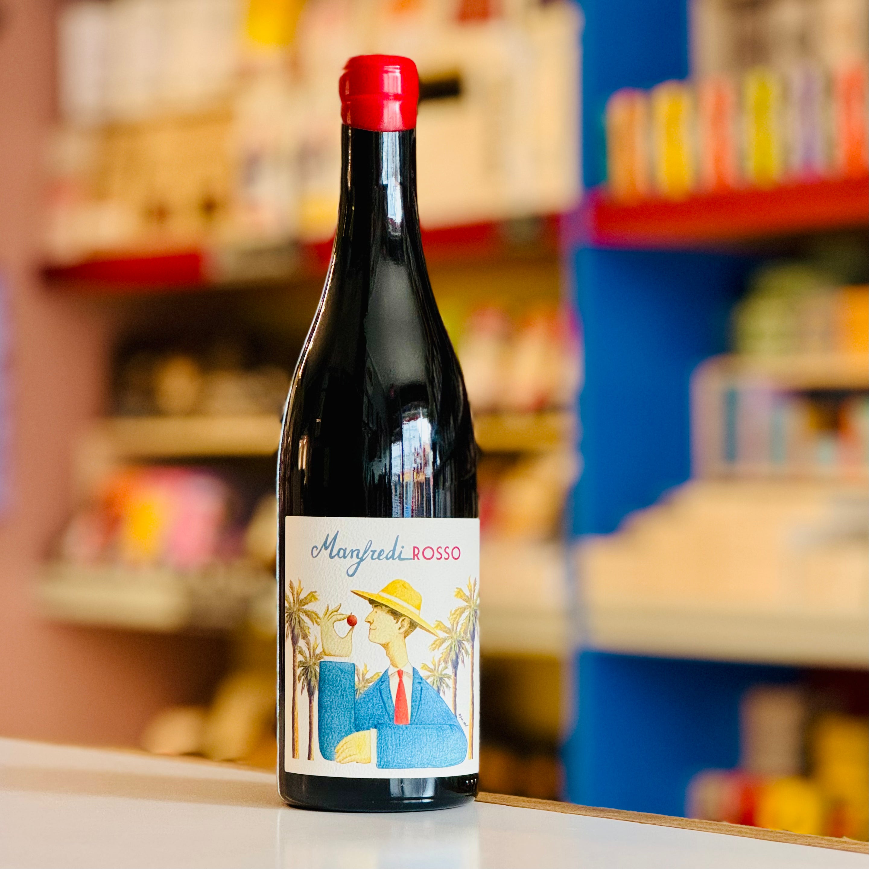 Bottle of Manfredi Rosso wine with a colorful label on a shelf background