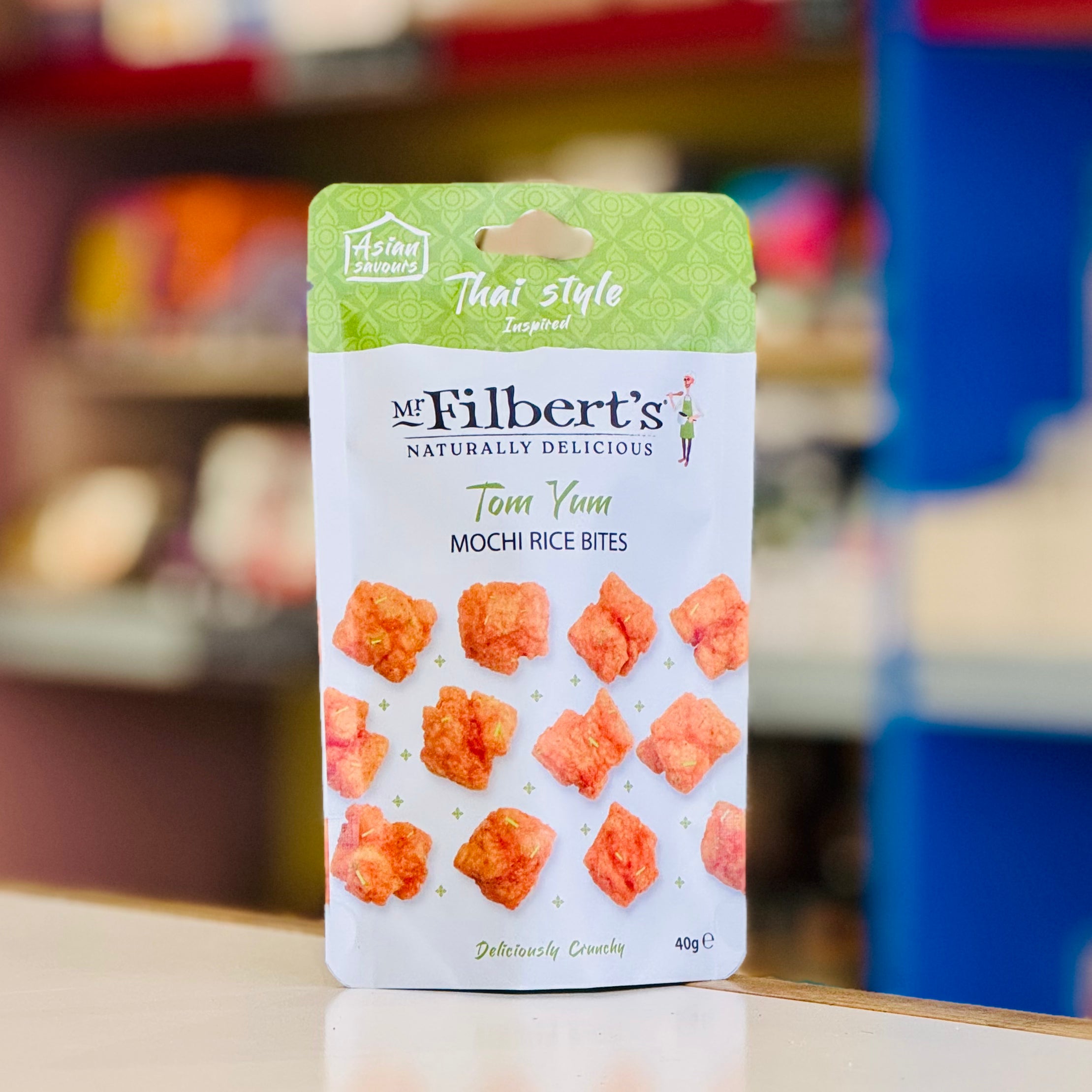 Packaging of Mr Filbert's Tom Yum Mochi Rice Bites with a blurred store background