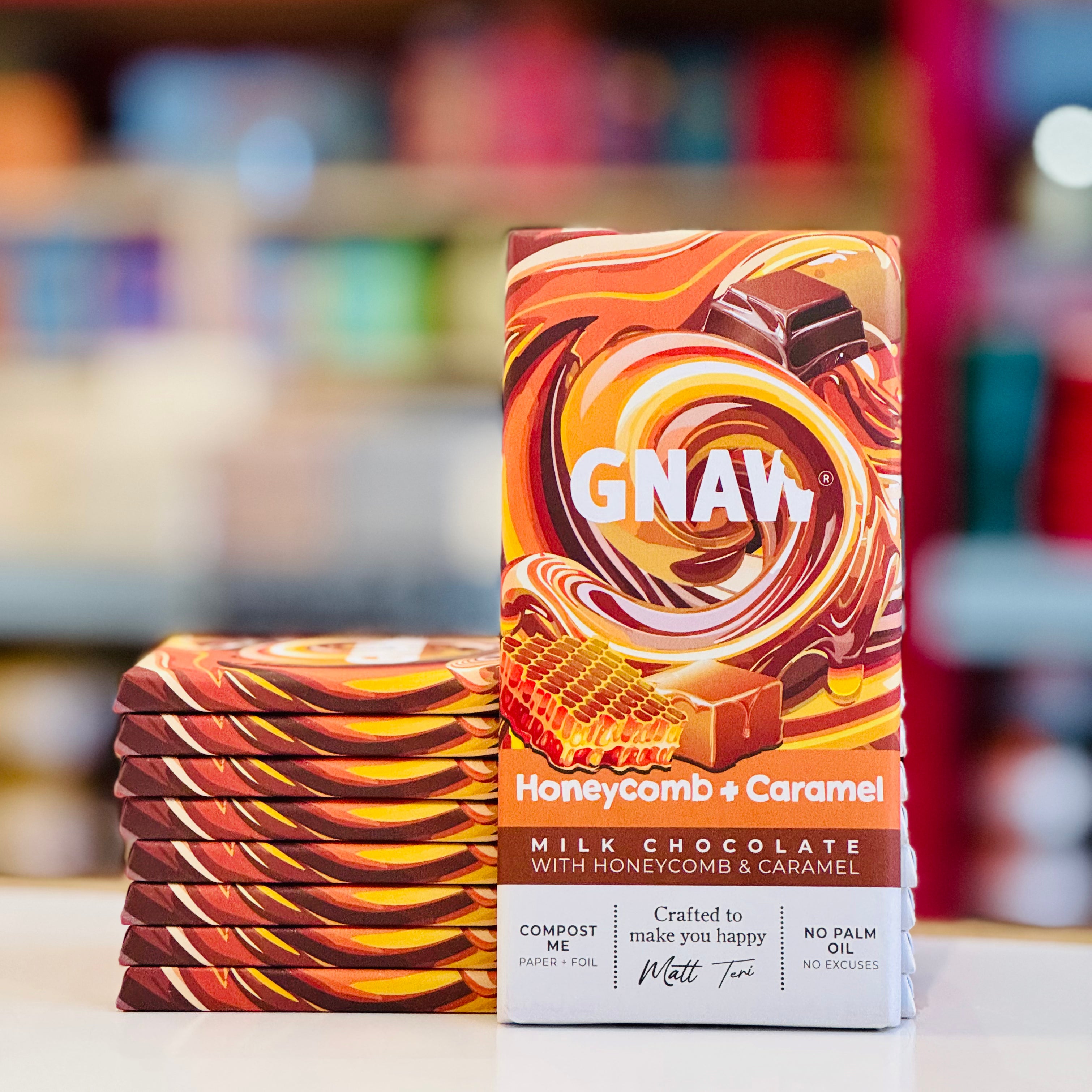 Stack of GNAW Honeycomb & Caramel milk chocolate bars with a colorful packaging design.