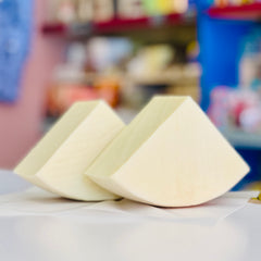 Two wedges of cheese on a table with a blurred background