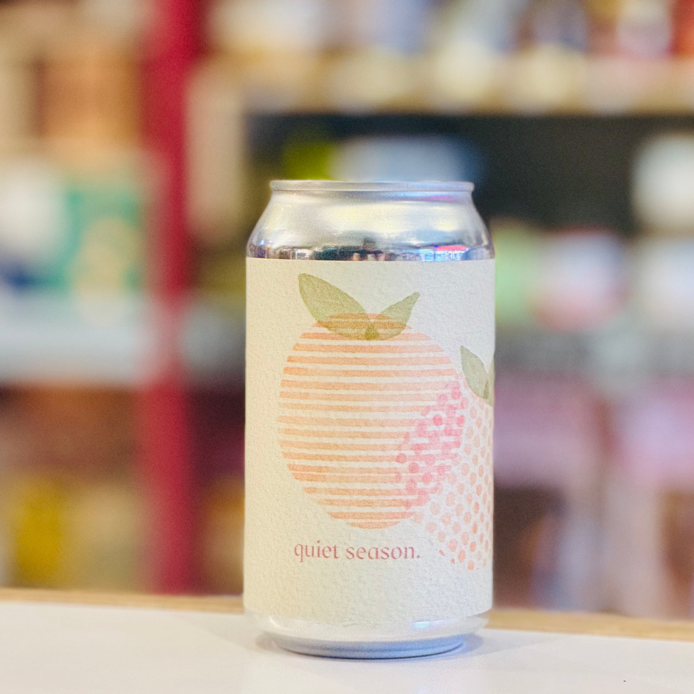 Can with a peach graphic and 'quiet season' text on a blurred background
