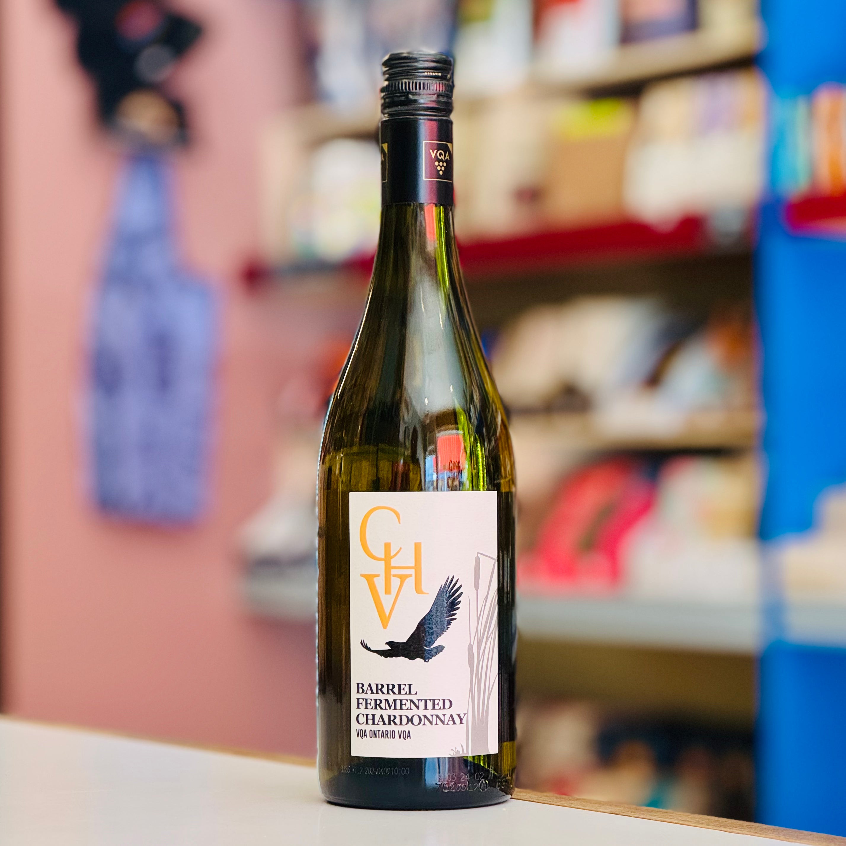 Bottle of Cooper's Hawk Vinyards Barrel Fermented Chardonnay wine on a shelf with blurred store background