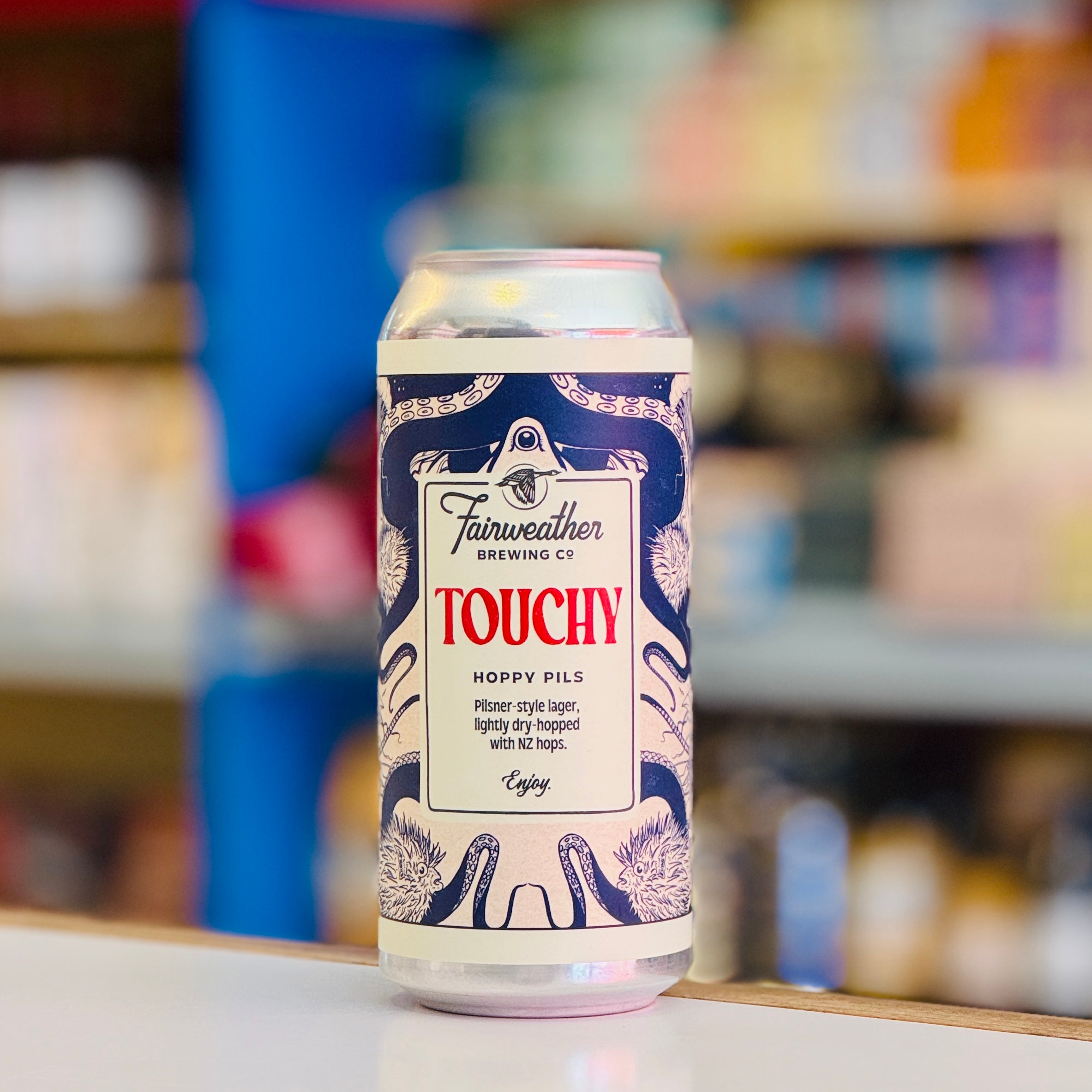 Beer can labeled 'Touchy' by Fairweather Brewing Co. on a blurred background
