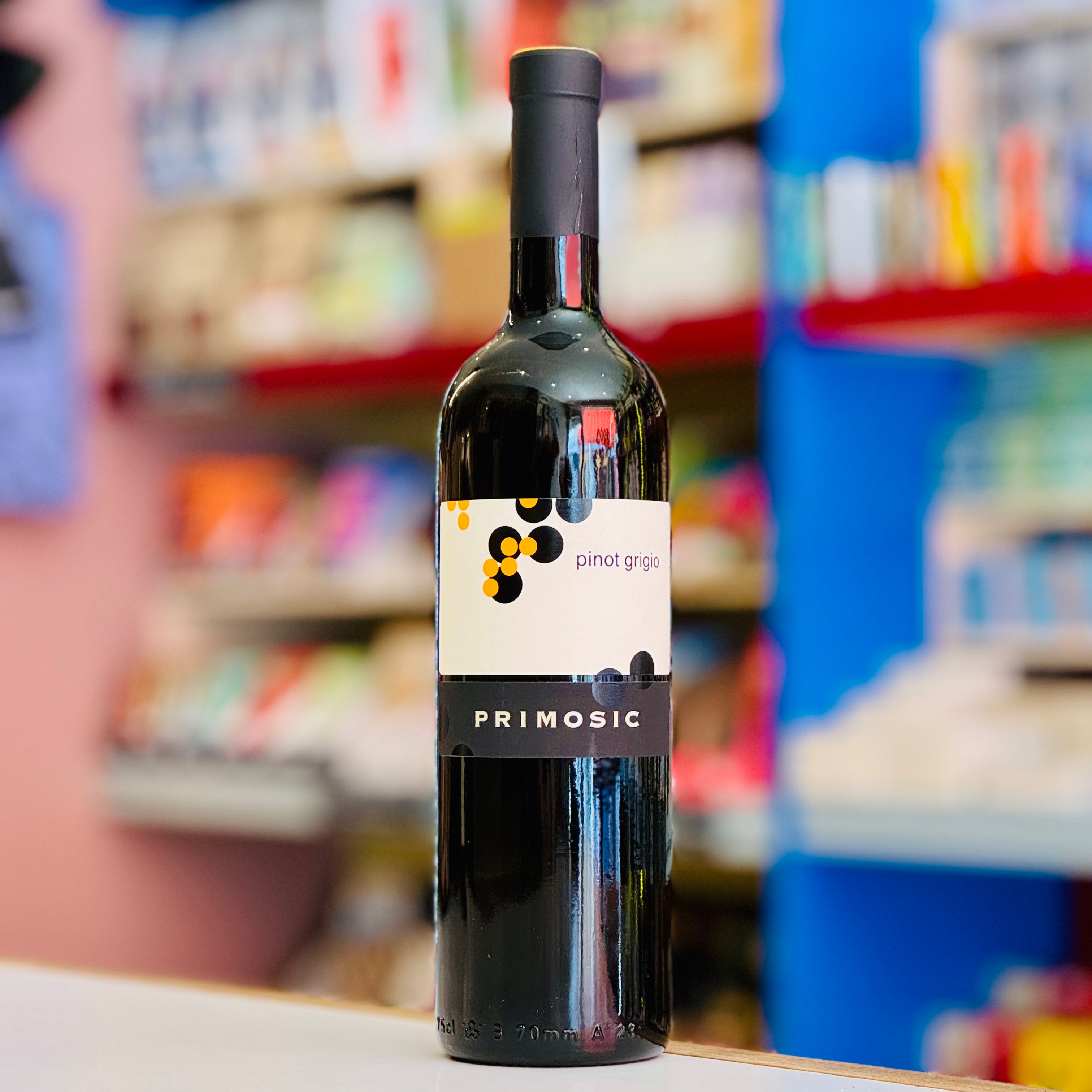 Bottle of Primosic wine on a shelf with blurred store shelves in the background