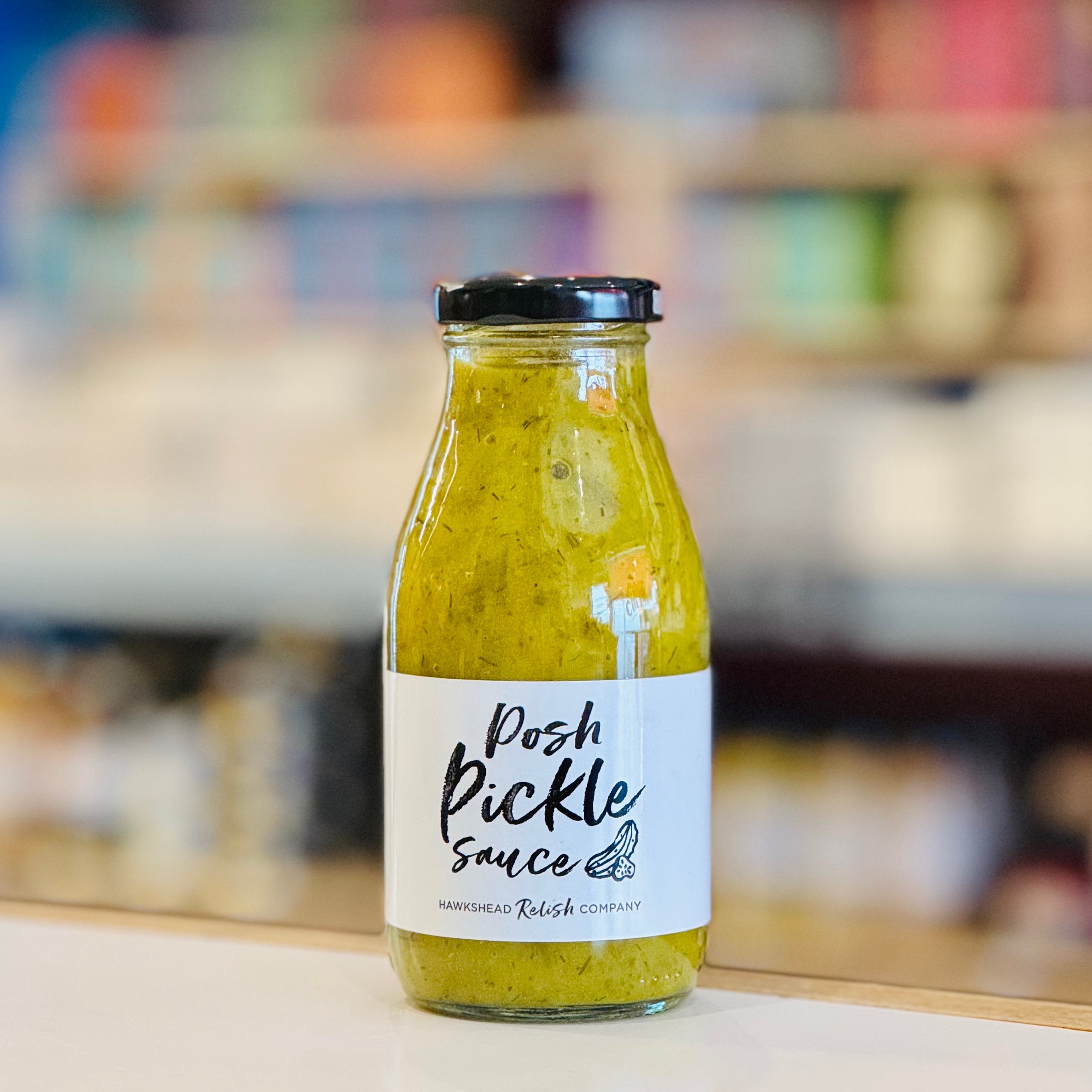 Bottle of Posh Pickle Sauce on a blurred background
